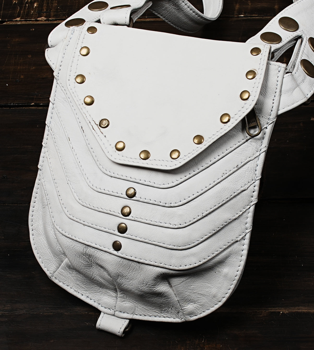 White leather harness bag with gemstone centerpiece and studs
