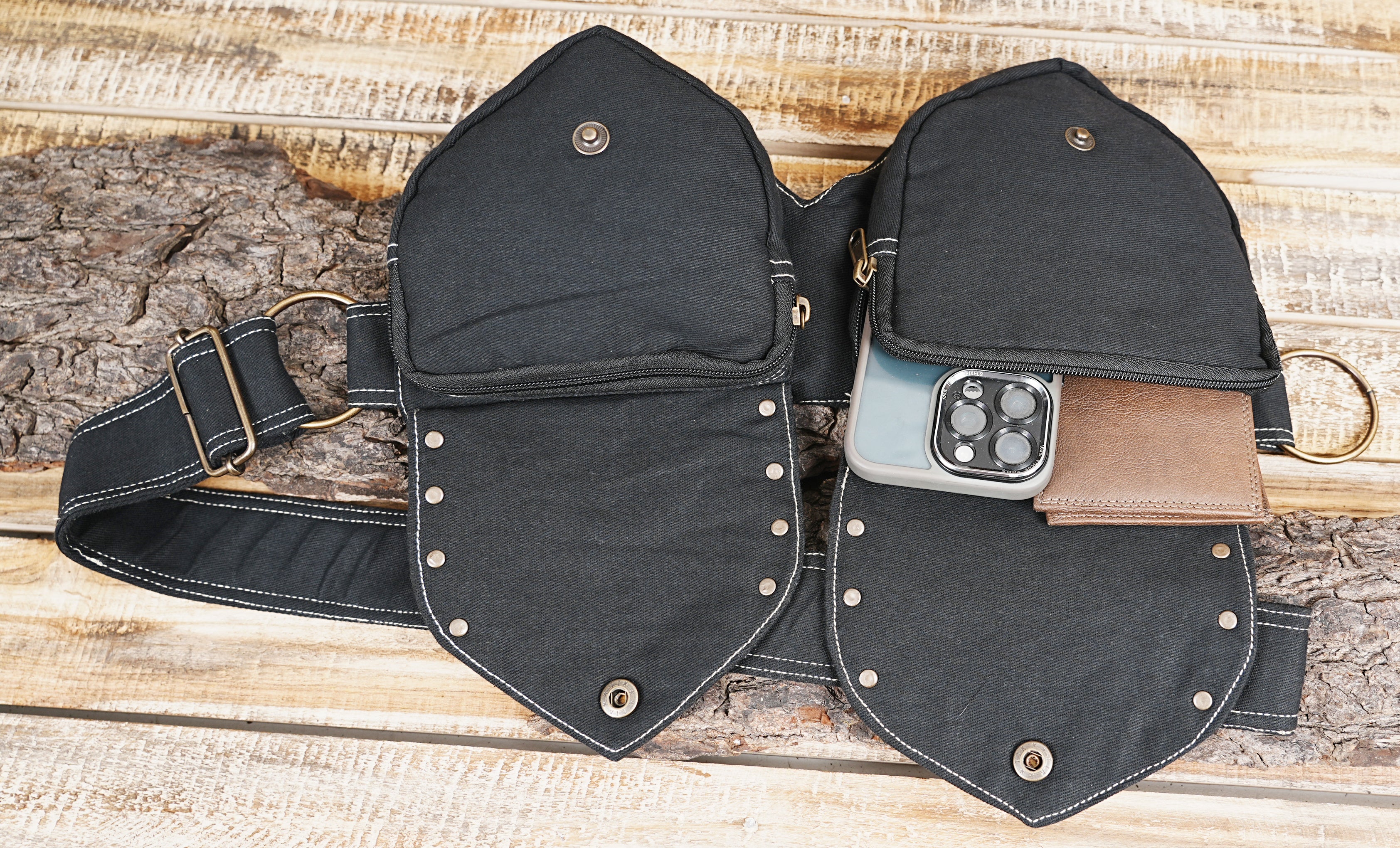 Handcrafted black cotton hip bag displayed on natural wooden background