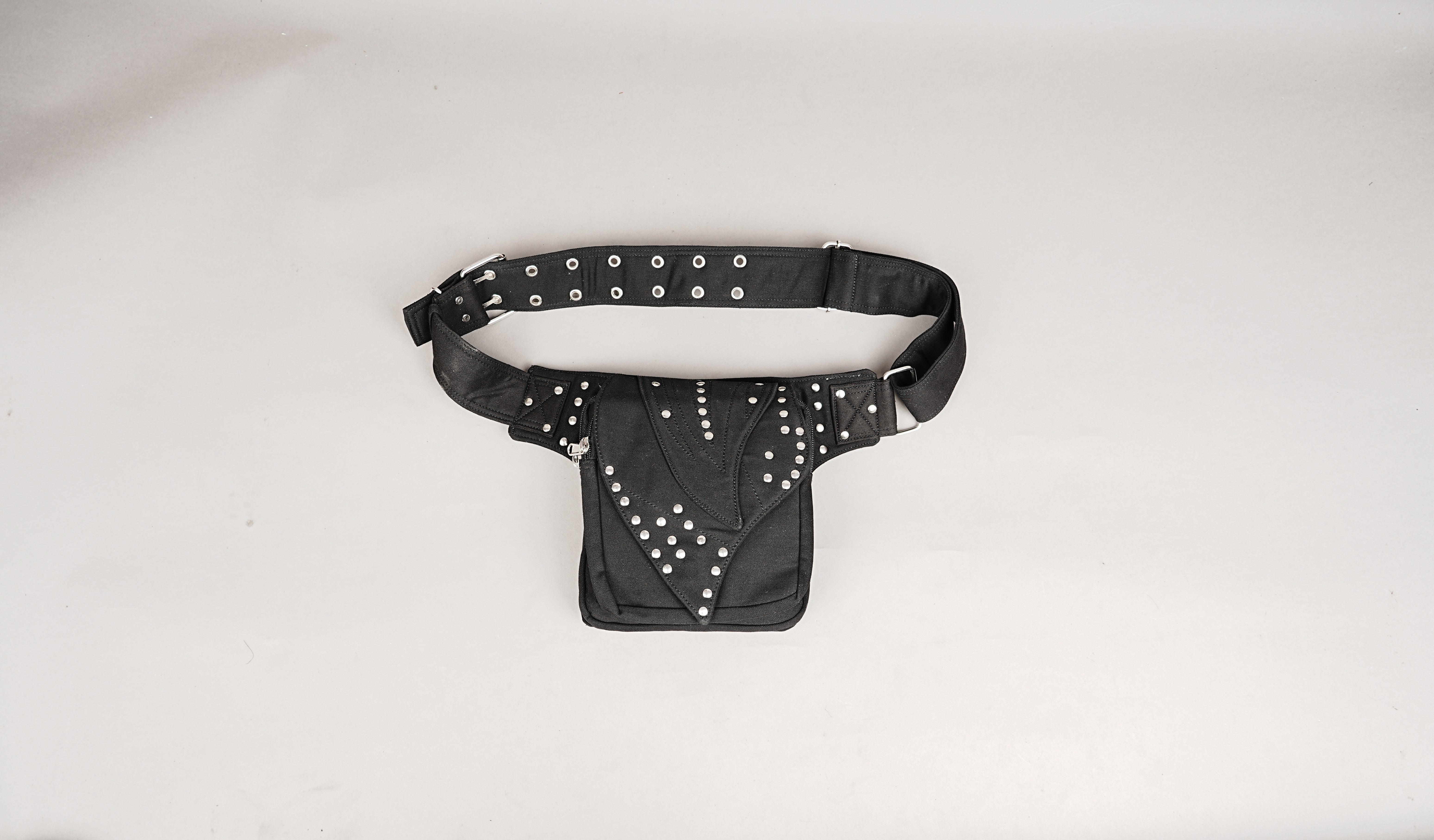 A top-down view of a black Gothic utility fanny pack with multi-pouch storage and studs, laid flat.