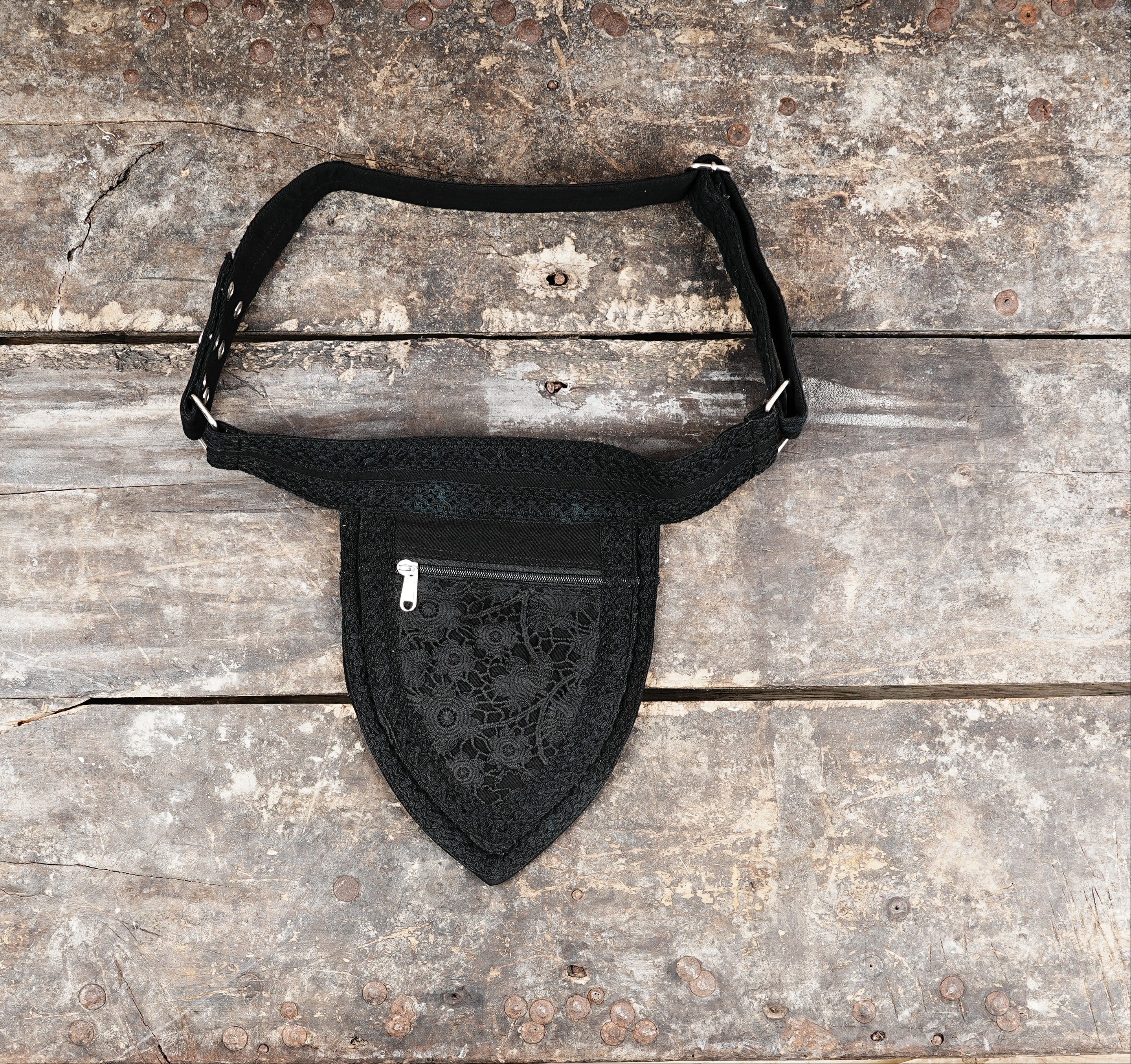 Close-up of a black cotton waist belt bag featuring a delicate lace overlay pattern.