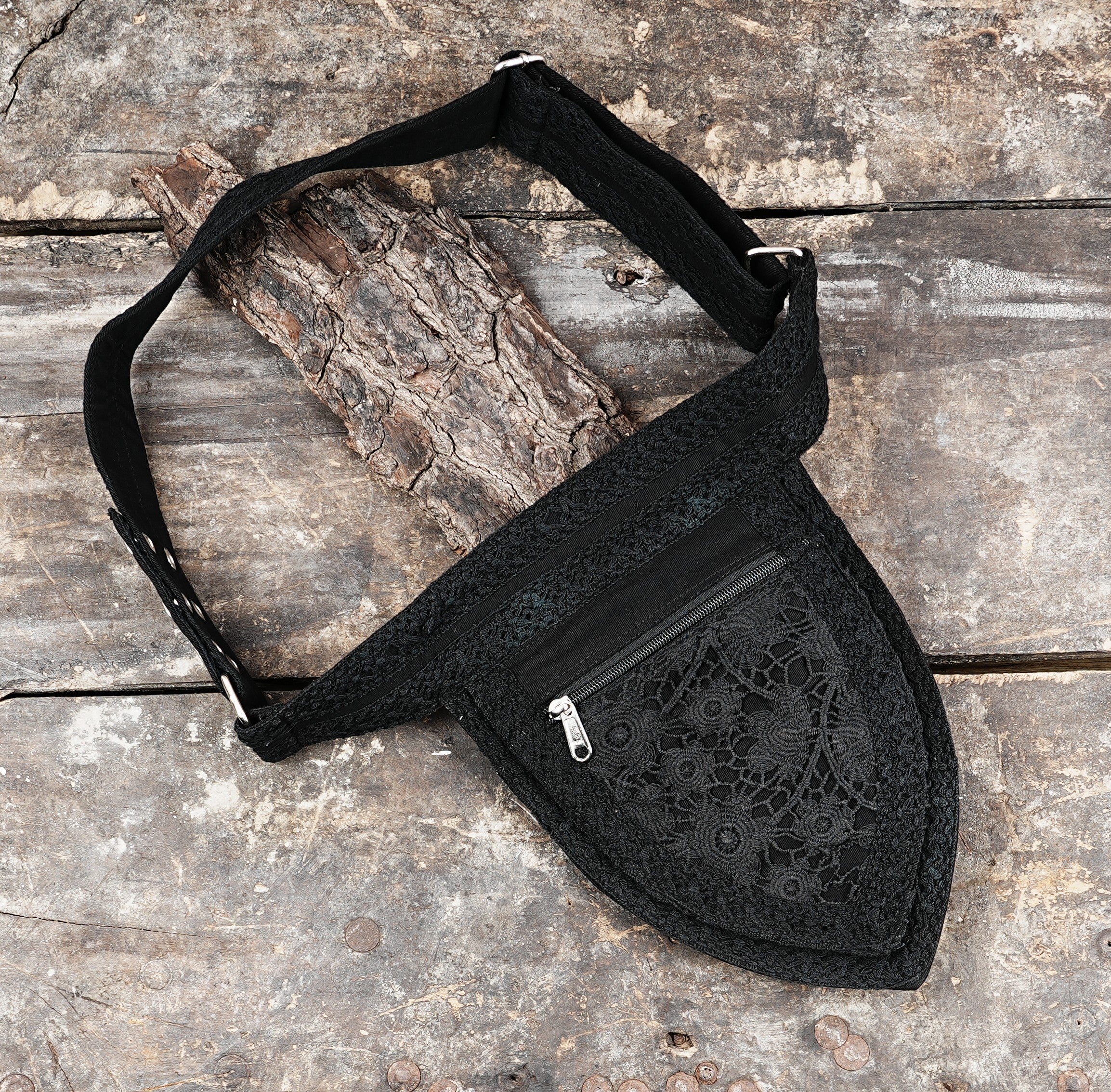 Stylish and secure black crossbody fanny pack with detailed lace panel and adjustable strap.