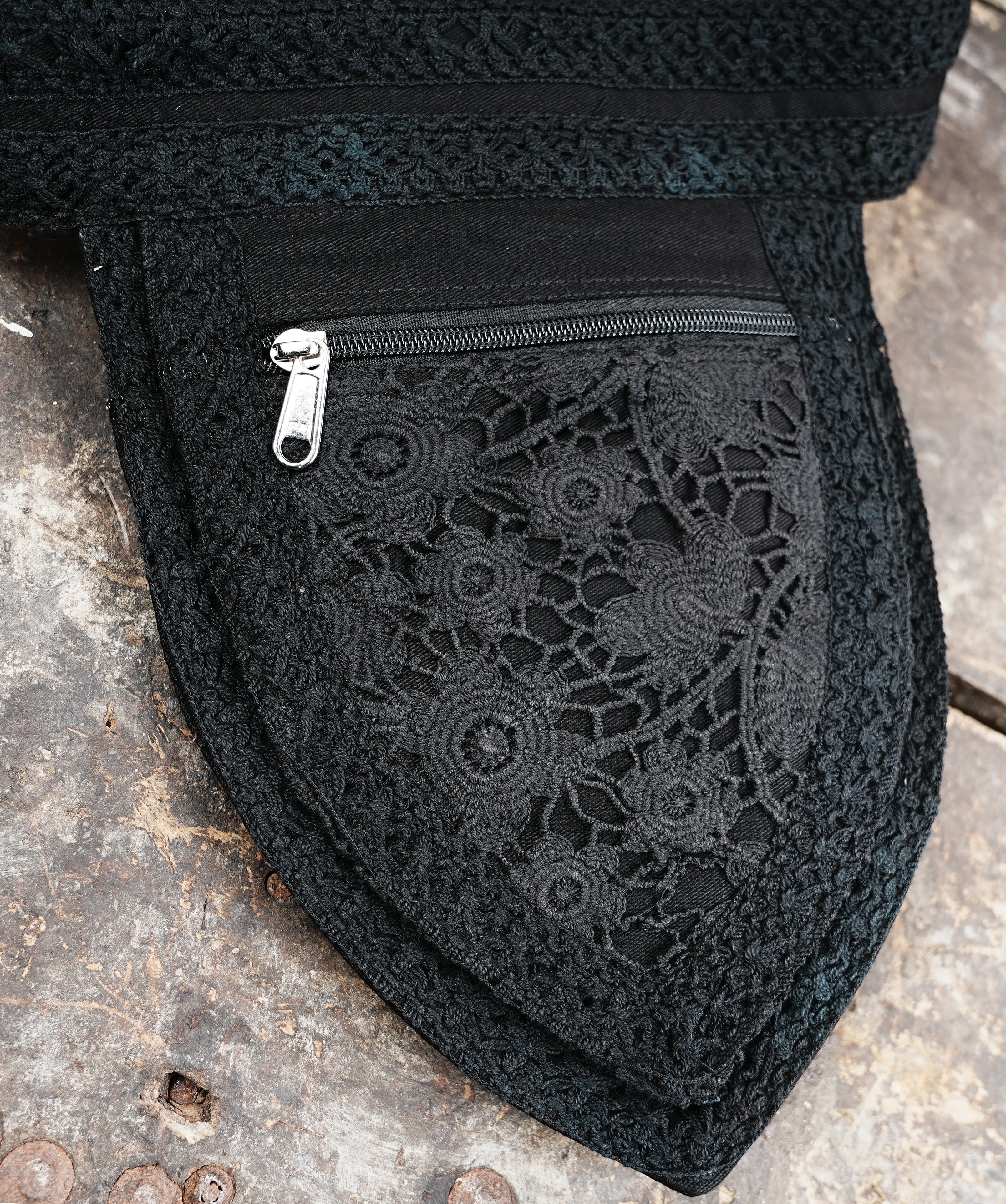 Alternative style black utility hip belt pouch with intricate floral lace trim and metal hardware.