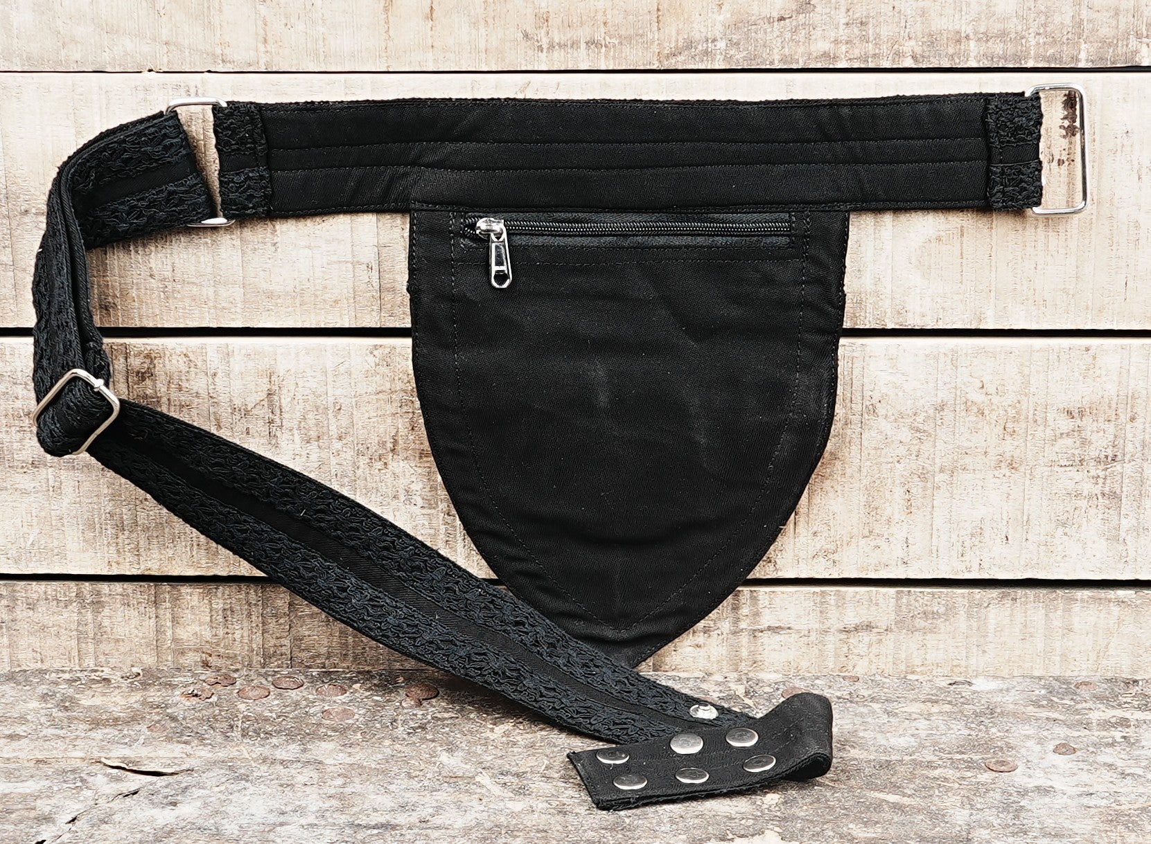 A woman wears a black lace fanny pack as a crossbody bag, keeping her hands free at a festival.