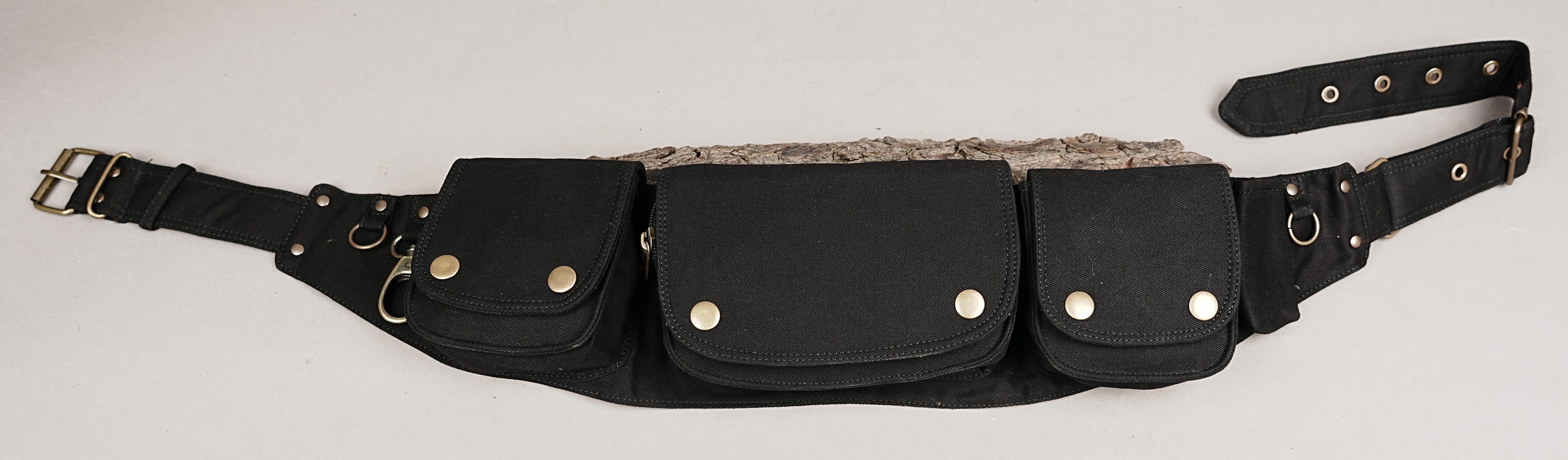 Alternative style utility belt with three main pouches and brass studs on a rustic timber surface.