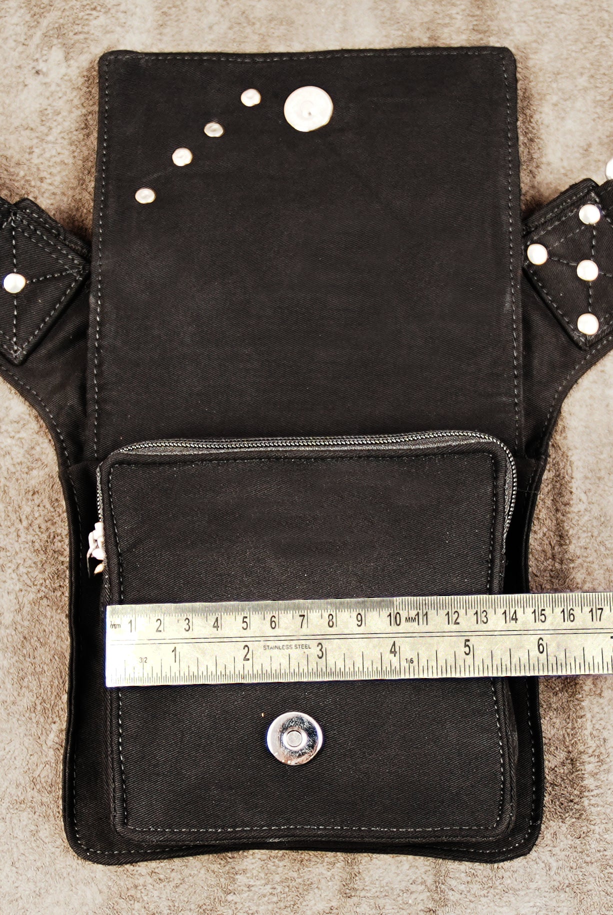 USA/Generic: Durable black fanny pack with mesh and metal details for men or women on a neutral background.