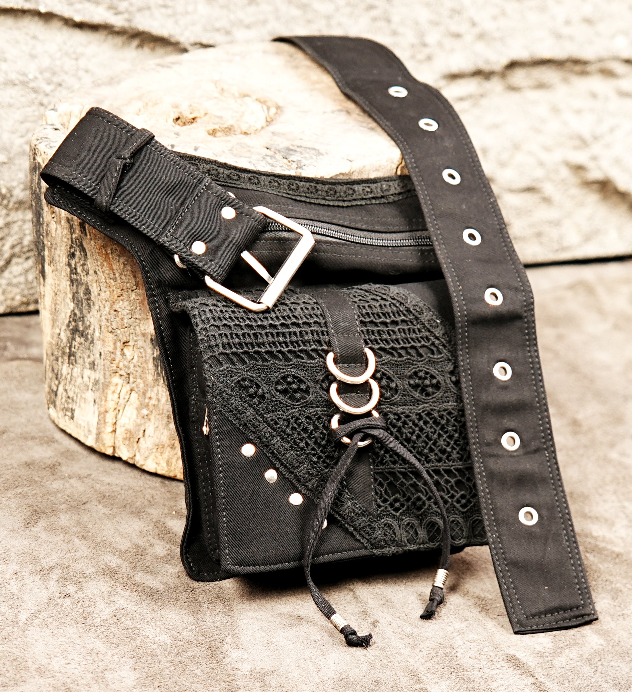 Alternative fashion black waist bag with an asymmetrical design, mesh texture, and metal hardware.