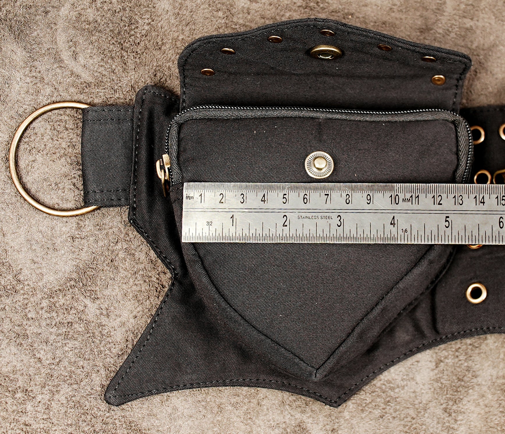 Edgy black hip bag with grommet detail, ideal for burning man style