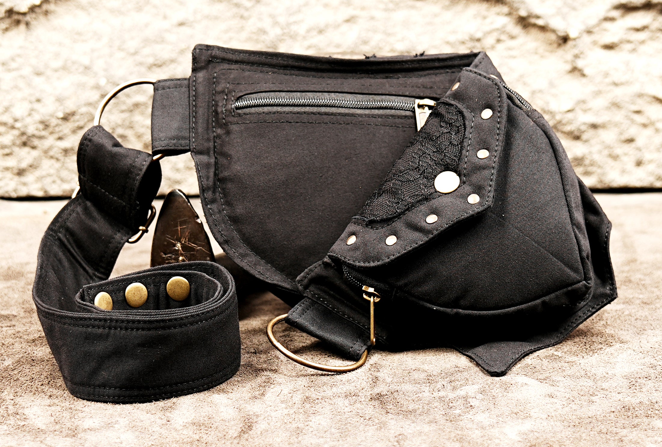 Black utility hip bag with studded pocket flaps and D-ring straps