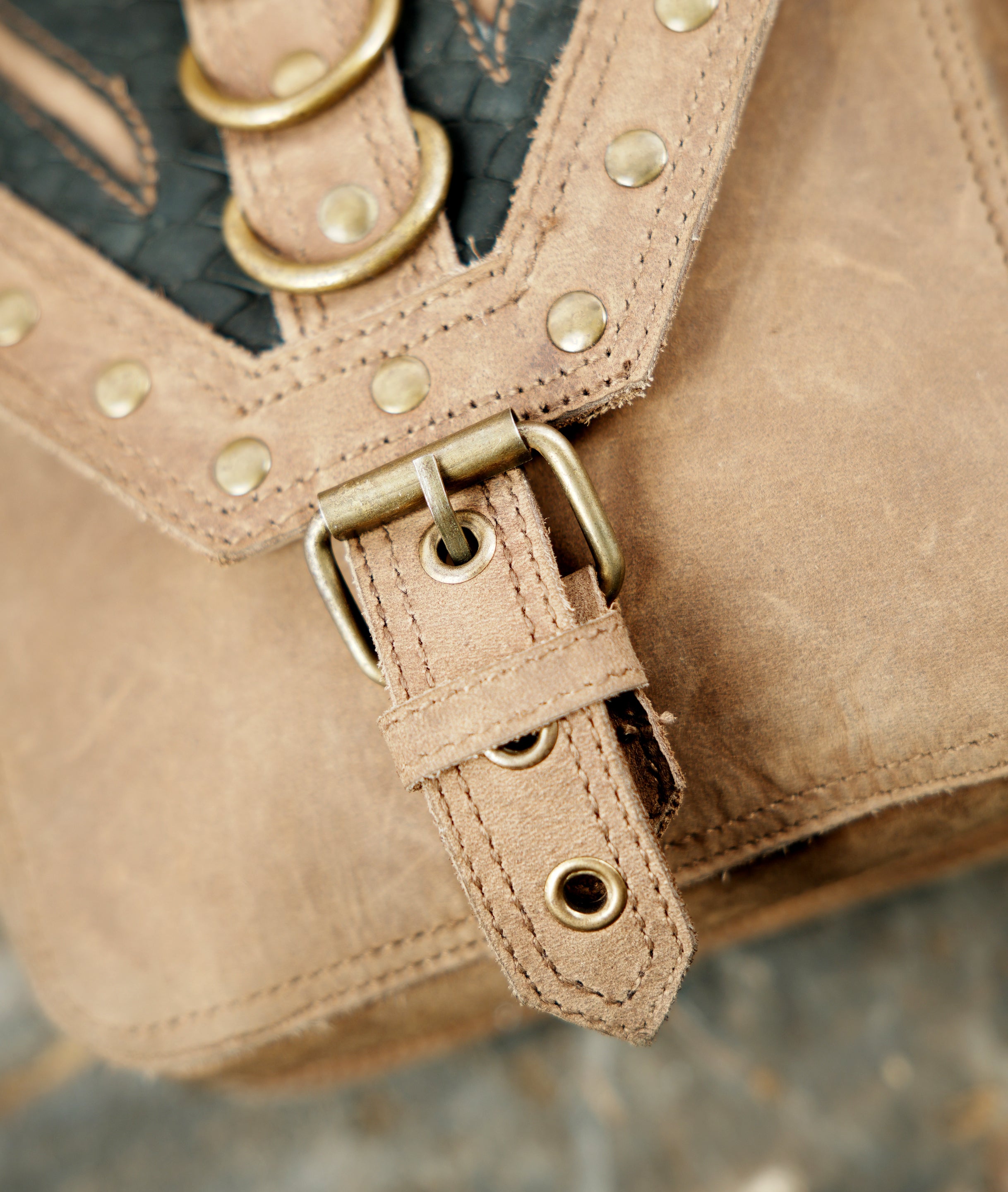 Artisan leather harness bag with studded flap design