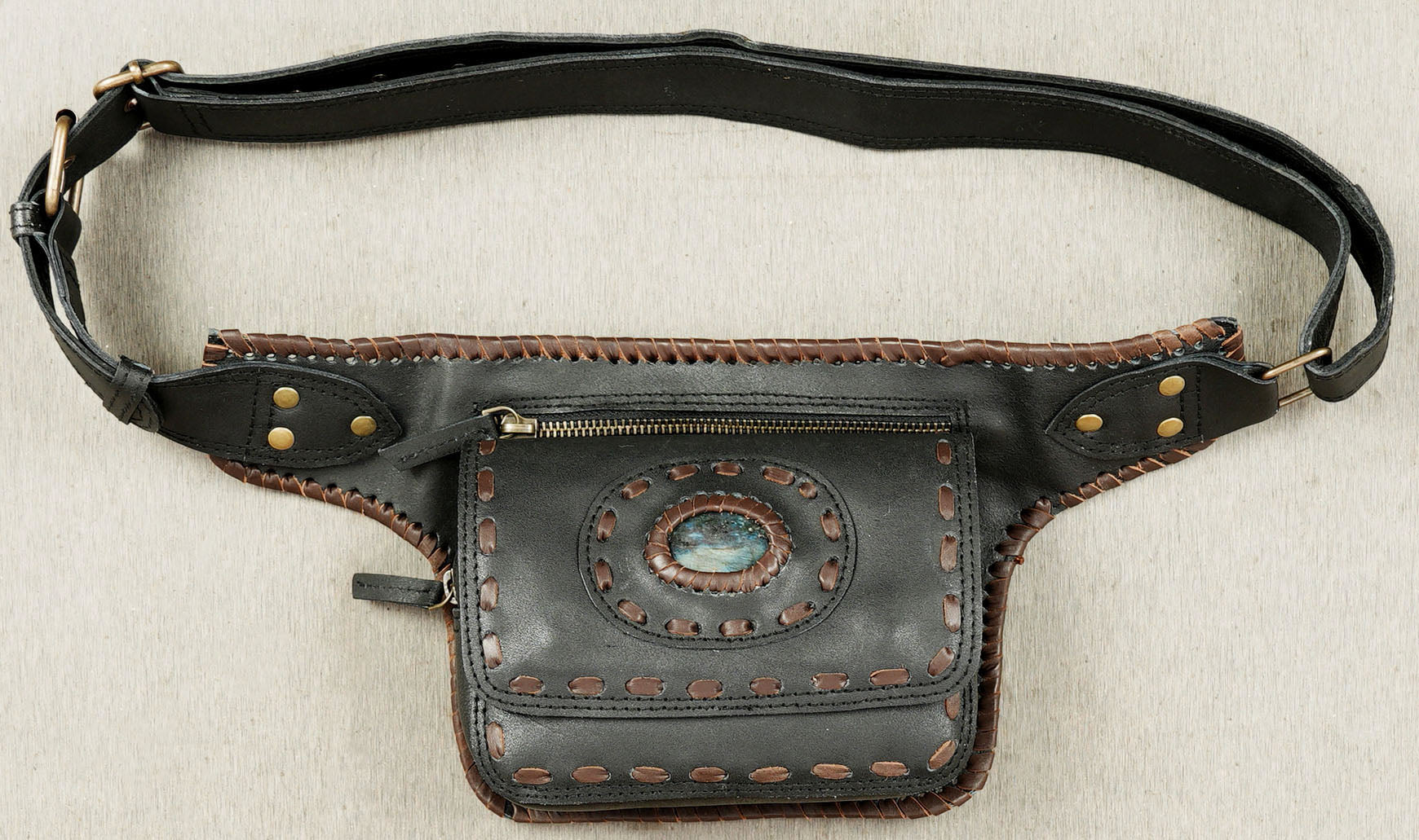 Rustic brown leather hip bag with gemstone inlay and braided design
