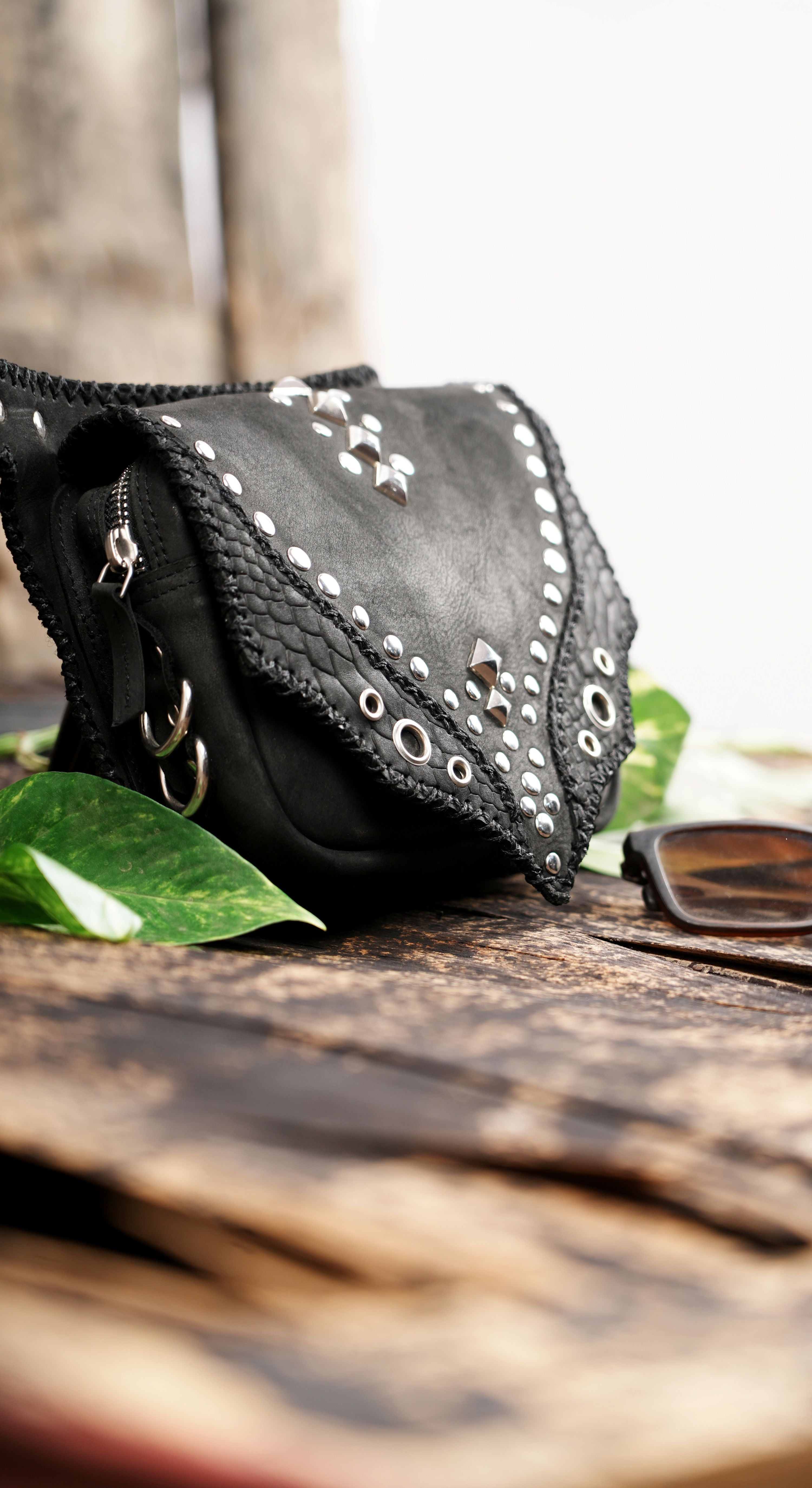 Durable black leather waist bag with metal eyelets