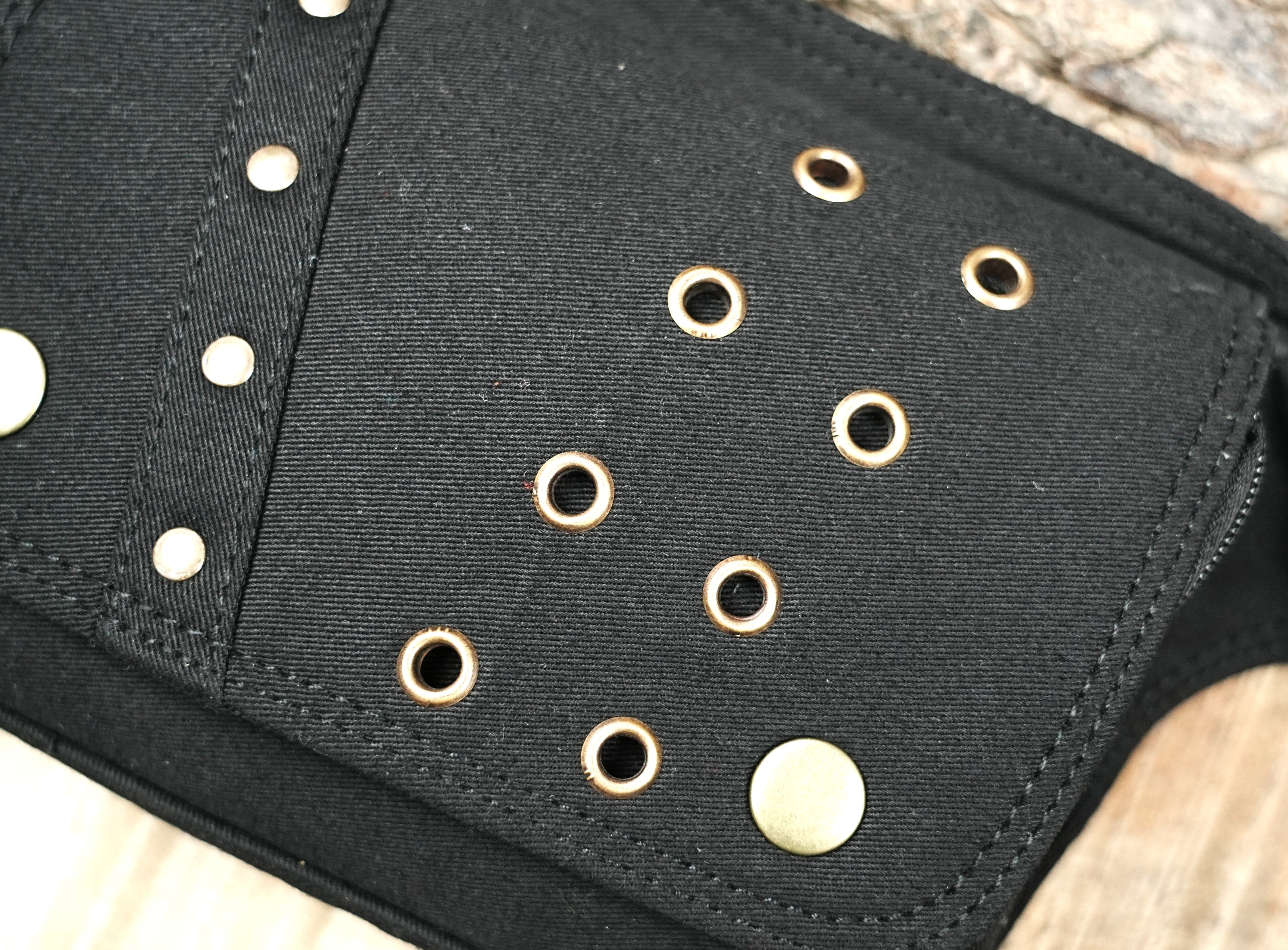 Minimalist black hip bag attached to a sturdy waist strap with metal studs.