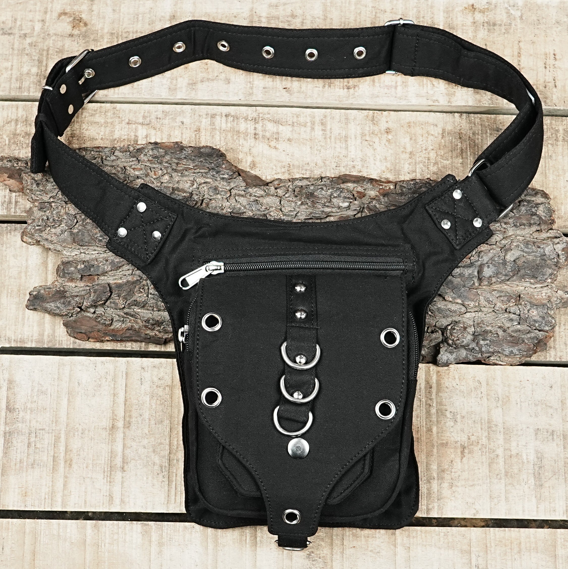 "A rugged black canvas utility belt bag, often called a drop leg pouch, designed for hands-free convenience during festivals or hiking." (USA/Aus)
