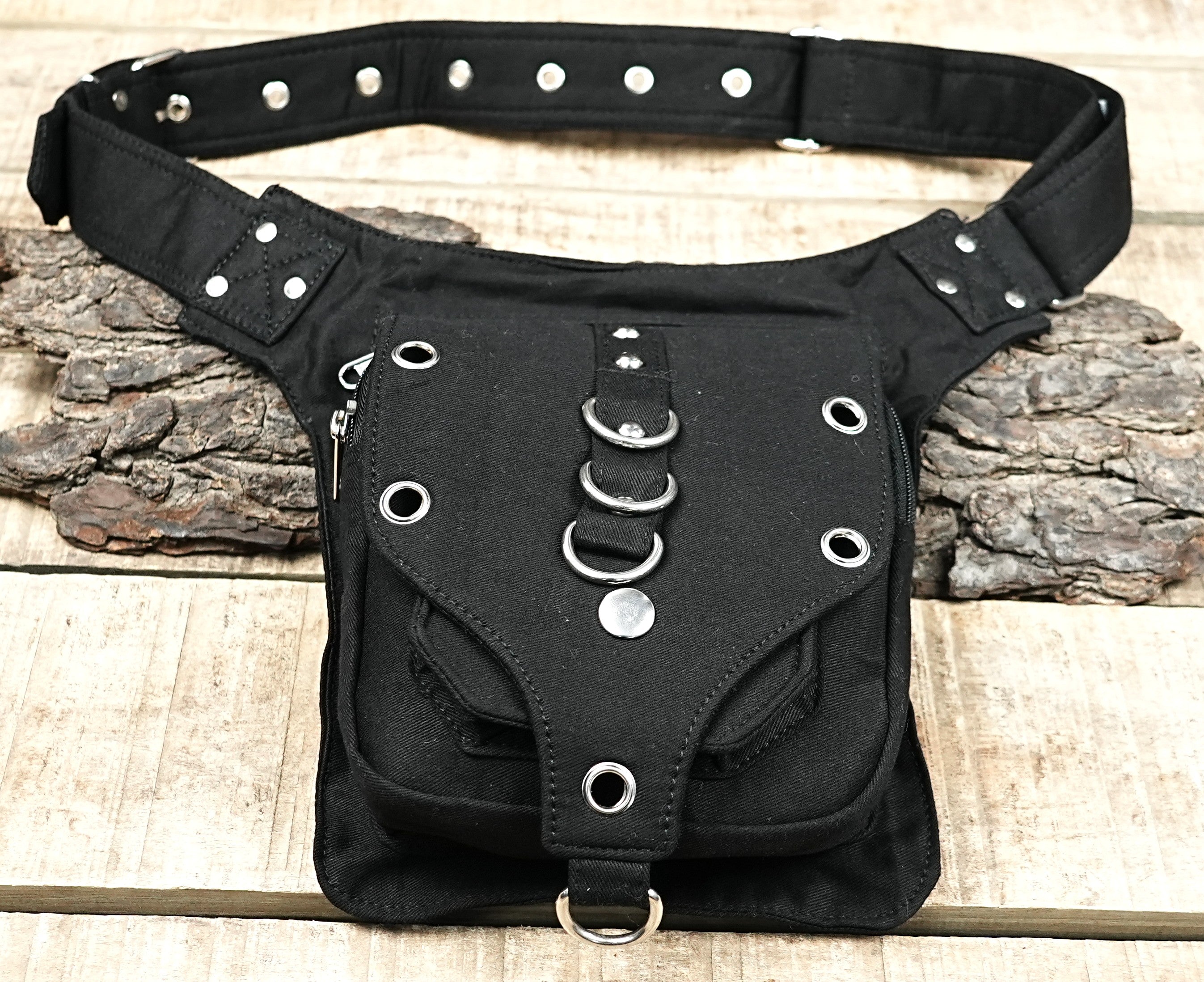 "Steampunk style black canvas utility pouch, featuring metal rivets, a front flap with eyelets, and three central O-rings for an urban warrior look." (UK/Europe)