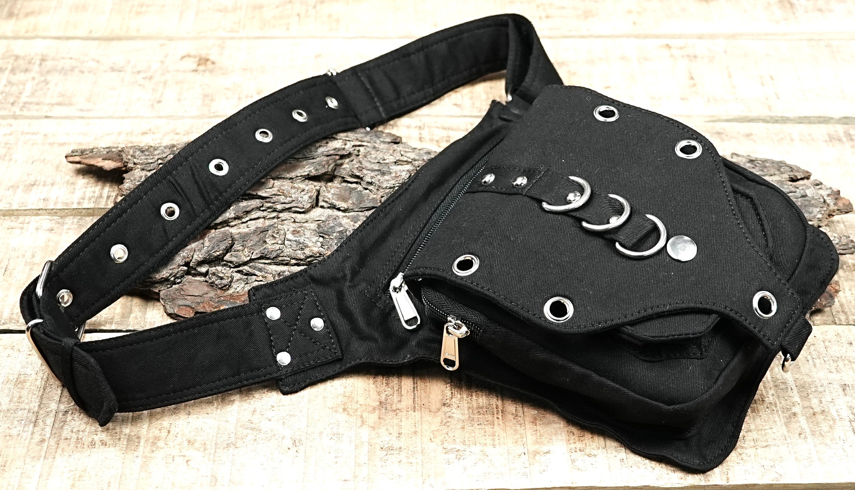 "A compact black festival bag with a unique studded front design and O-ring details, worn securely around the hip or thigh." (Europe)