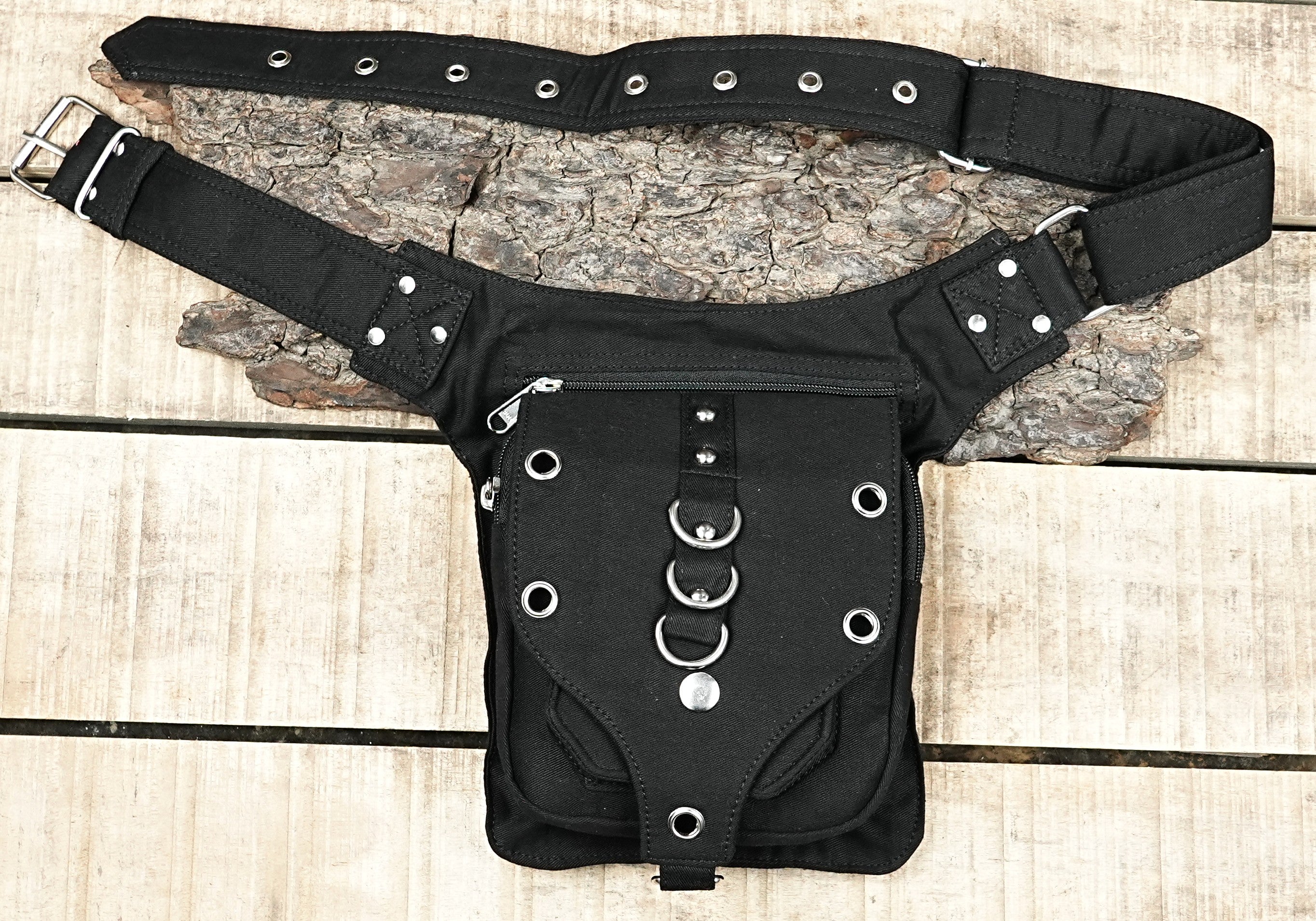 "Black canvas military-style utility pack with an adjustable belt, multiple zippers, and eyelet accents, great for motorcycle riding." (USA/Australia)