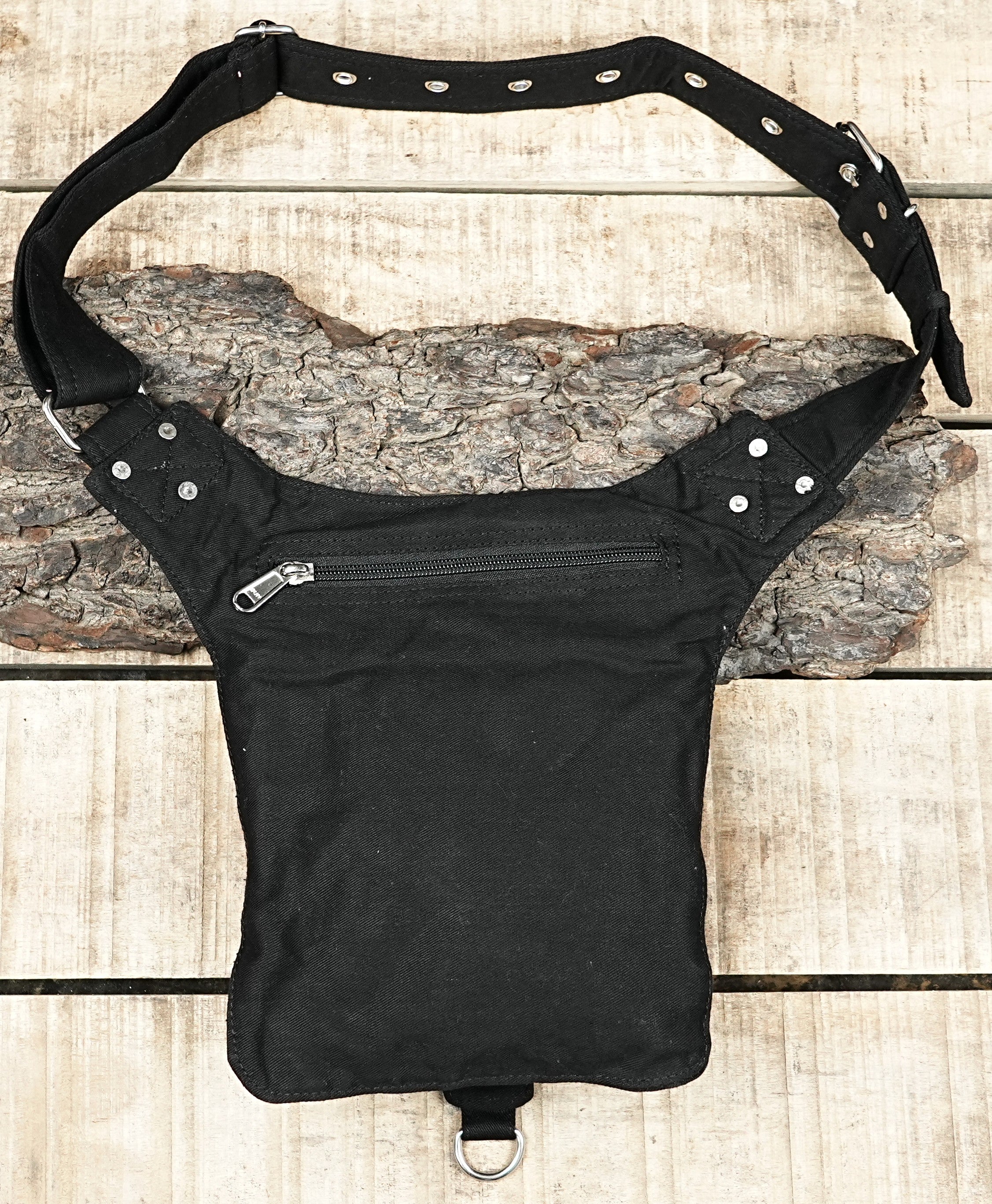 "Rugged black canvas pouch designed as a drop leg holster bag, featuring metal hardware, a front flap with eyelets, and an adjustable strap." (USA/Australia)