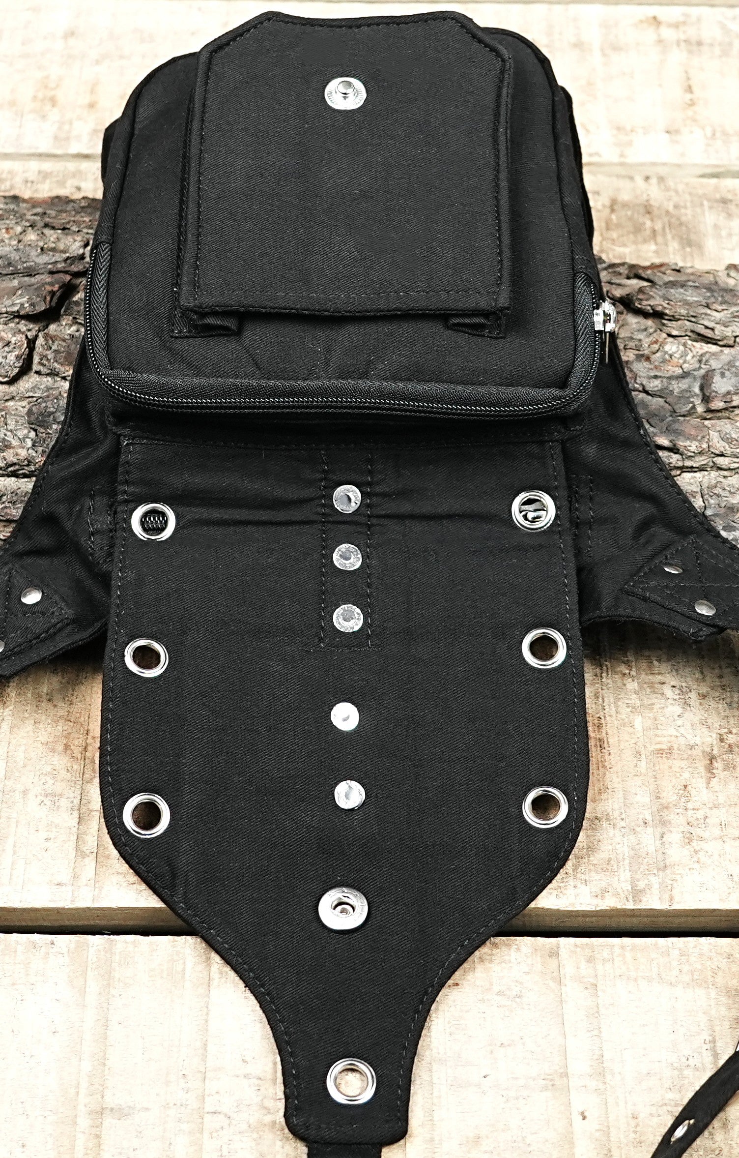 "A stylish, utilitarian black canvas leg rig with front flap, heavy-duty zippers, and a row of decorative O-rings for an edgy look." (UK/Australia)