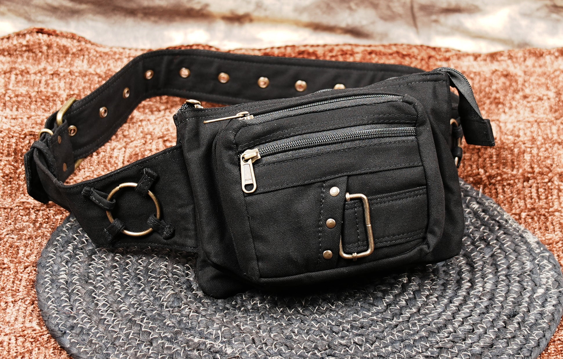Adjustable black hip bag with secure zip compartments and buckle detail