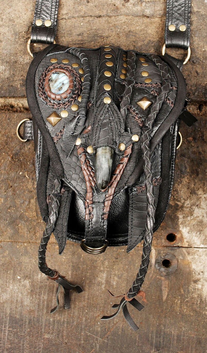 “Black snakeskin leather festival holster with stone inlays and metal studs”