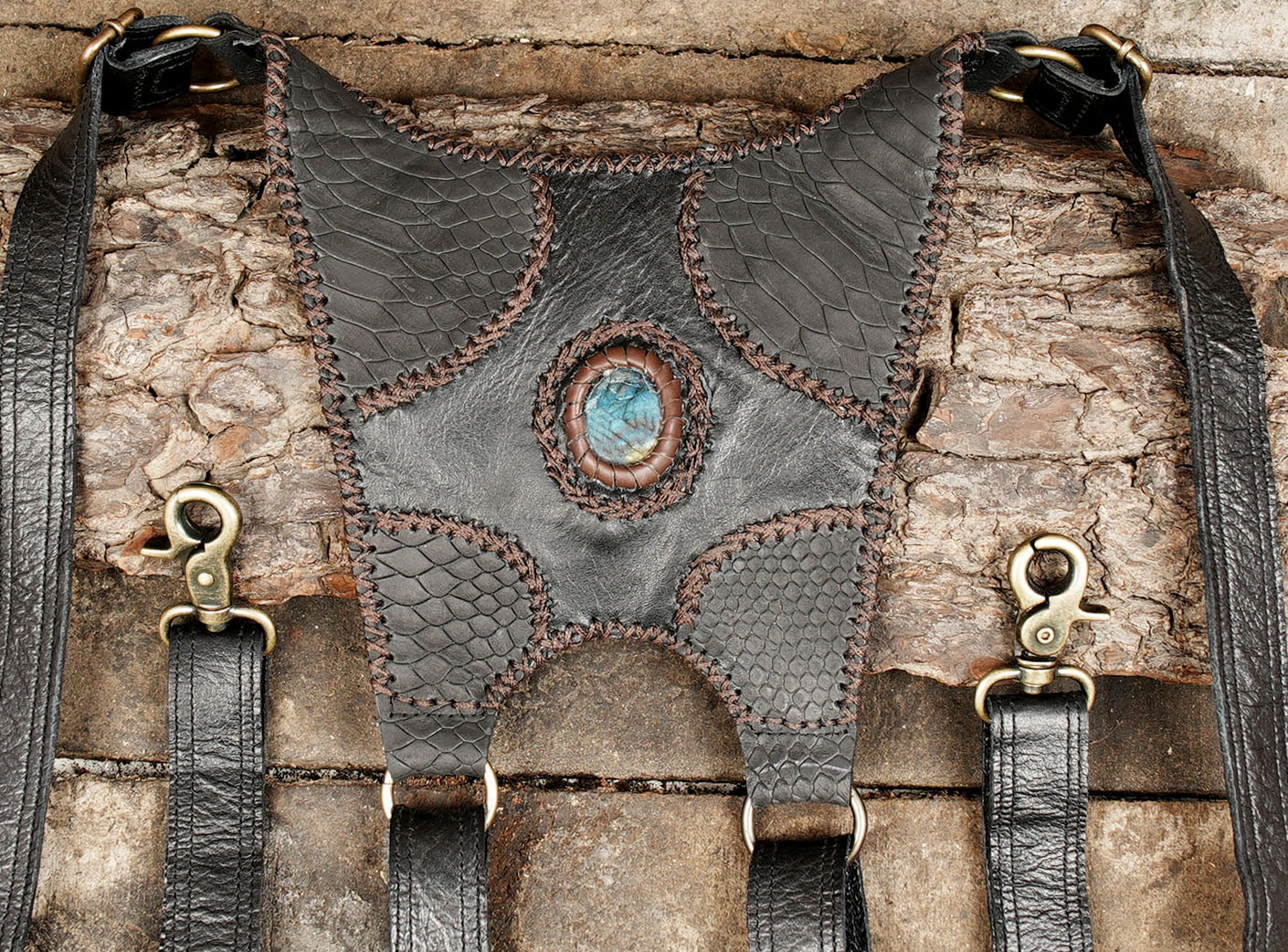“Handcrafted leather chest holster with gemstone panels and claw embellishment”