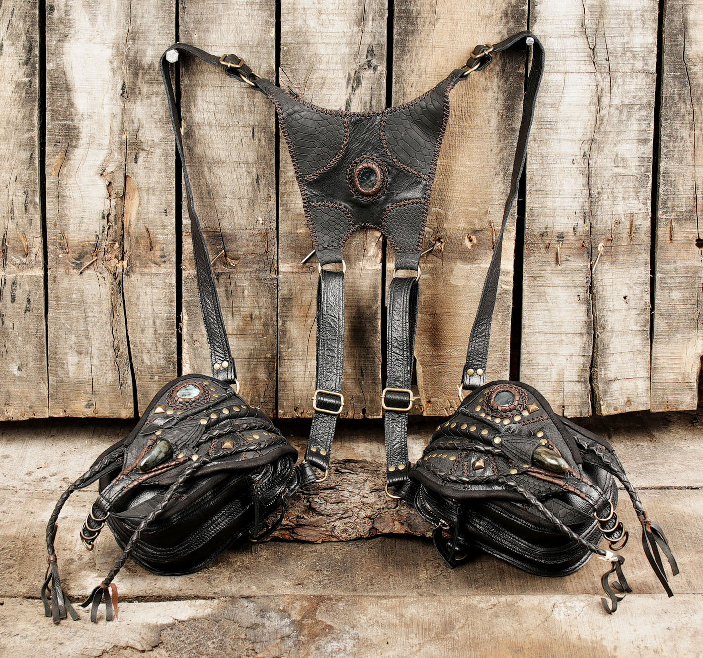 “Black leather shoulder holster with claw centerpiece and detailed stitching”