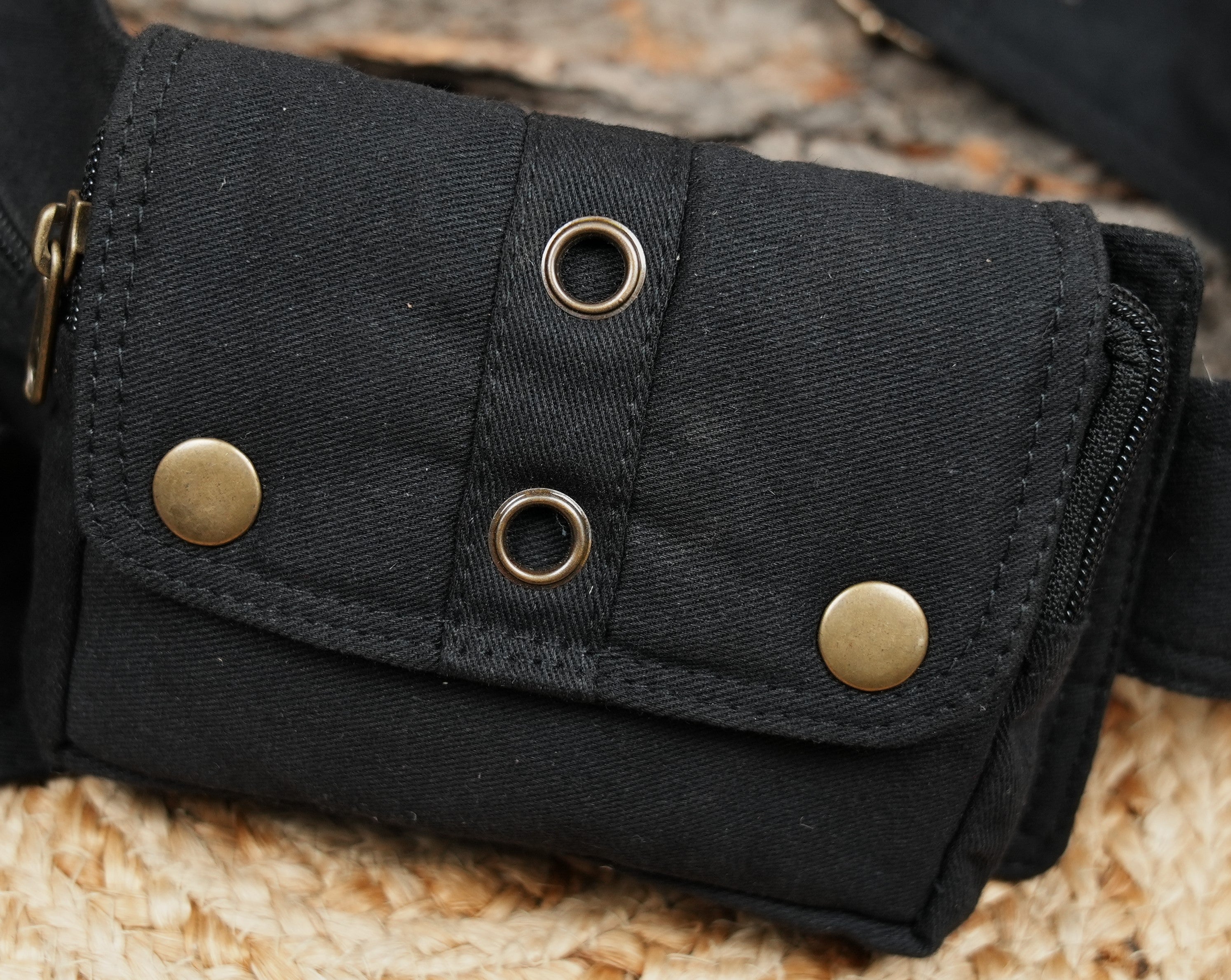 Hands-free black bum bag featuring laced pockets and grommets