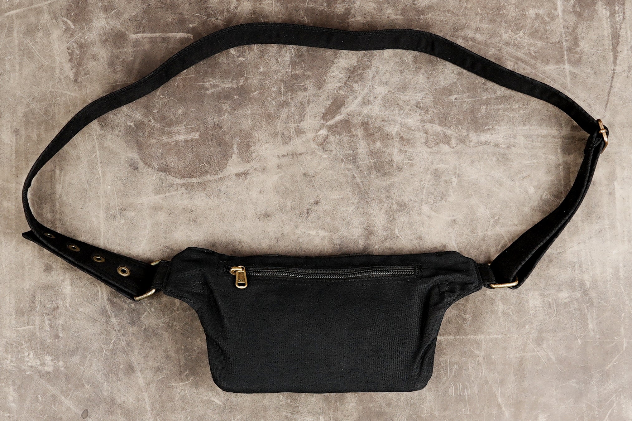 Black canvas hip pouch with multiple pockets and brass rings