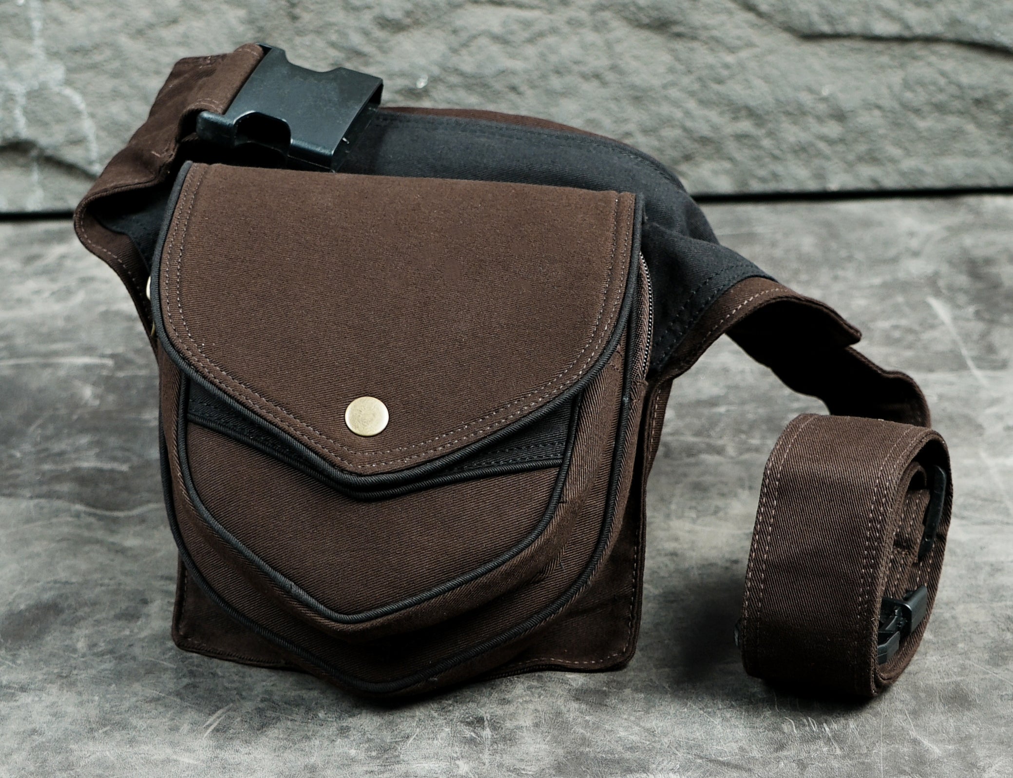 Brown cotton fanny pack with layered chevron pockets and brass snap closure