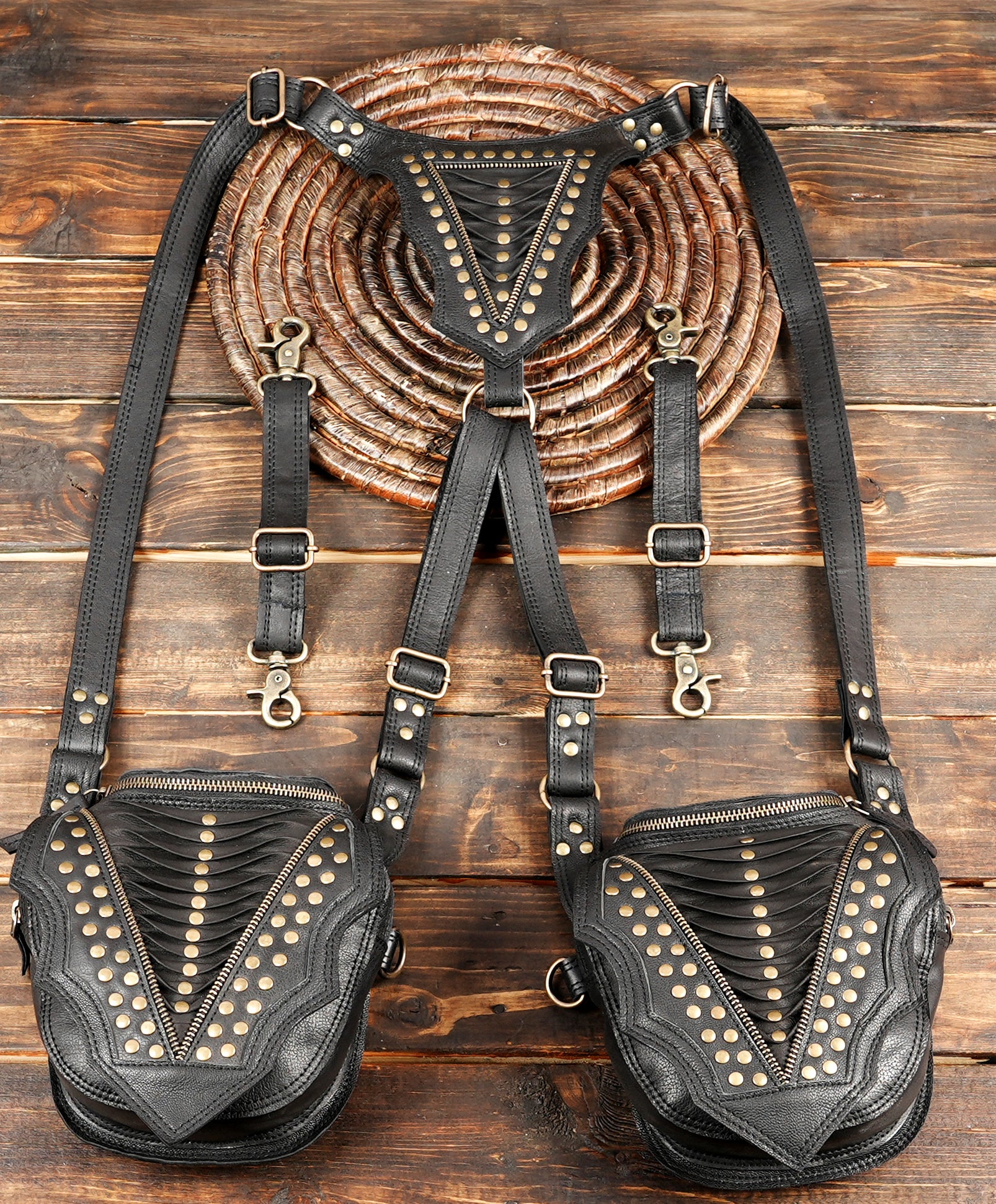 “Black leather holster harness with layered panel design and brass stud details”