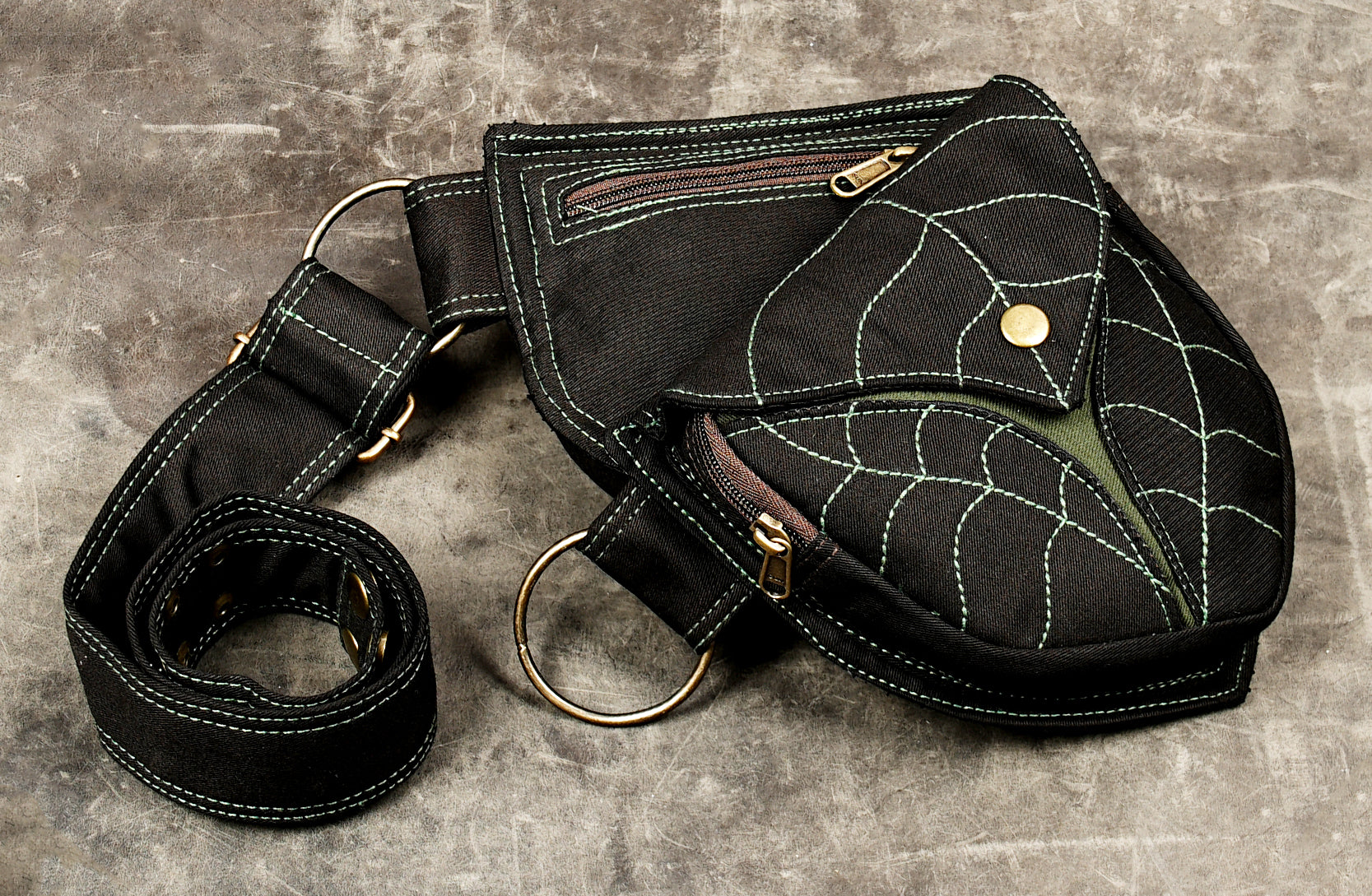 Black utility waist bag with dual flap pockets, brown accent inserts and side zippers
