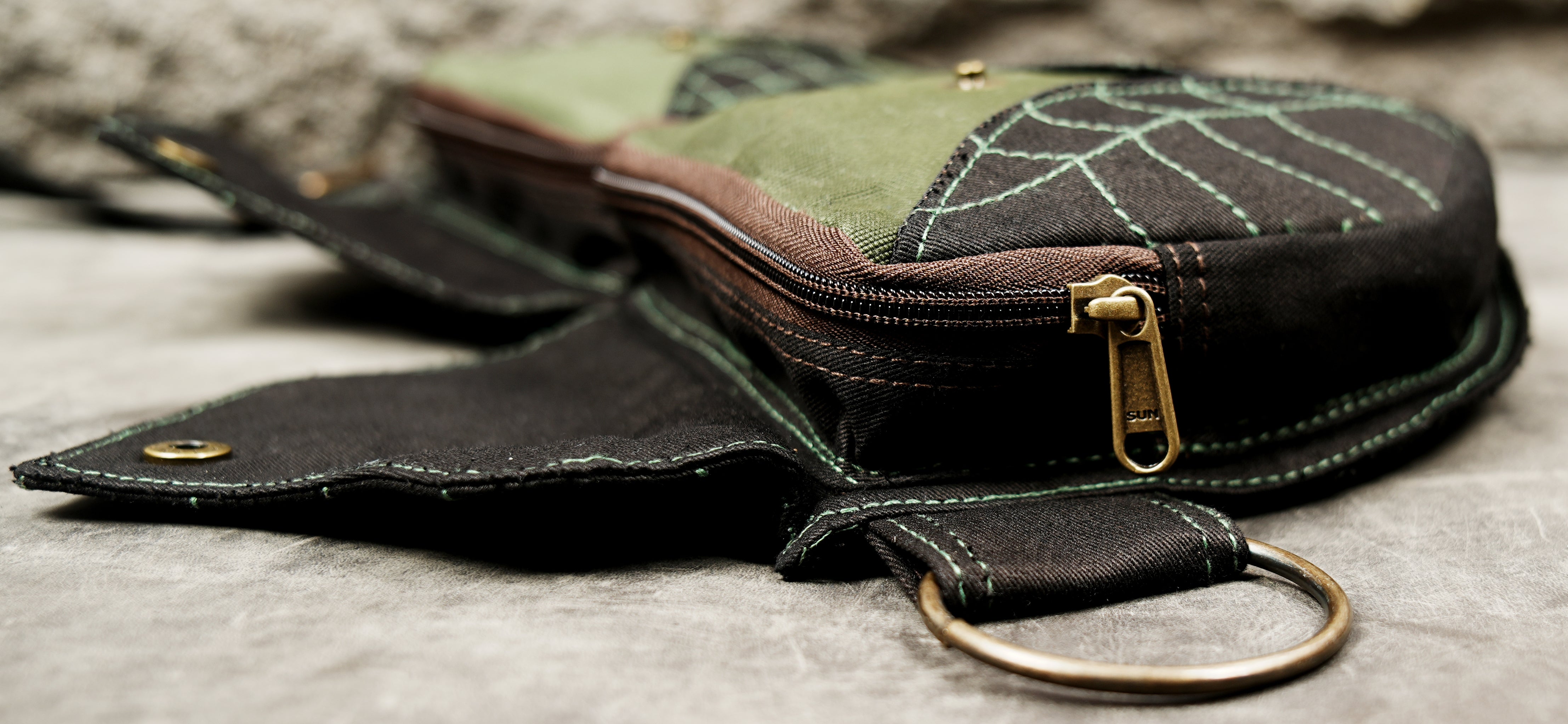 Black festival fanny pack belt with twin leaf-shaped pockets and brown fabric detailing