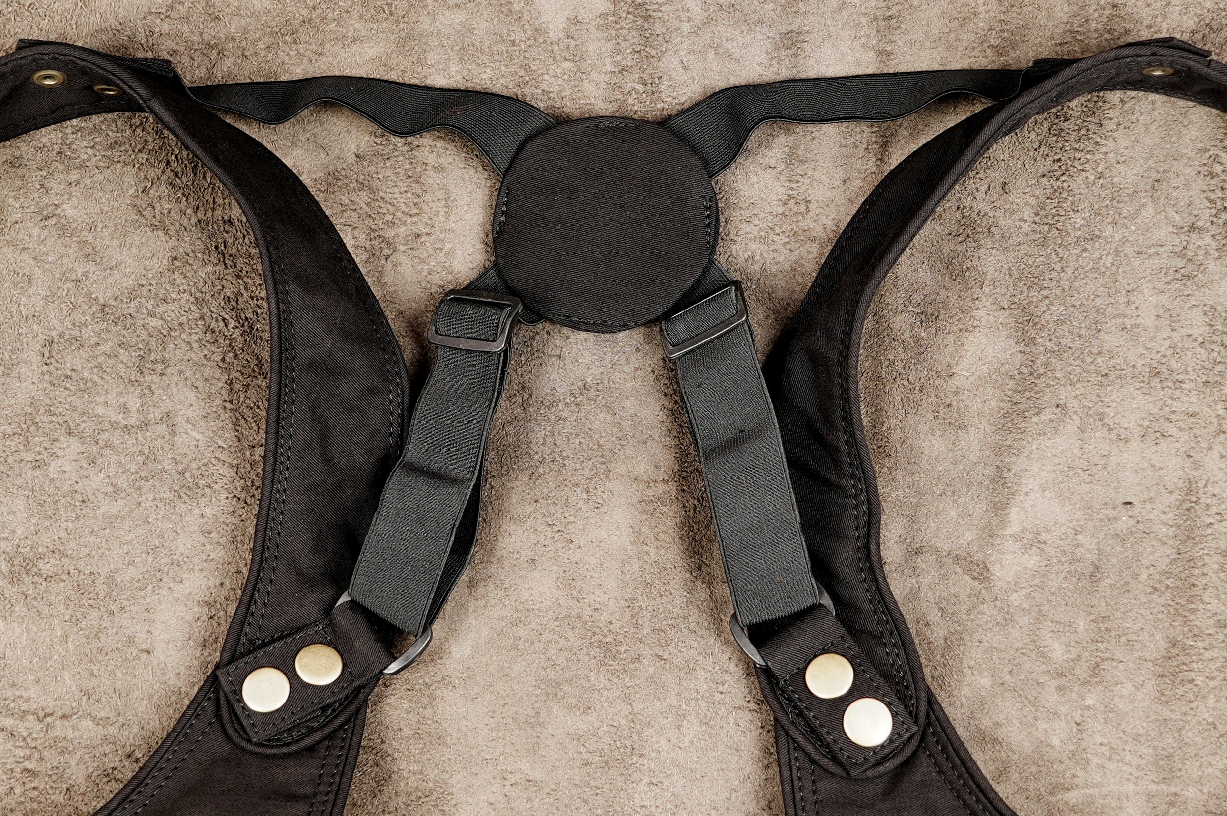 Black leather harness with adjustable straps and metal snap buttons