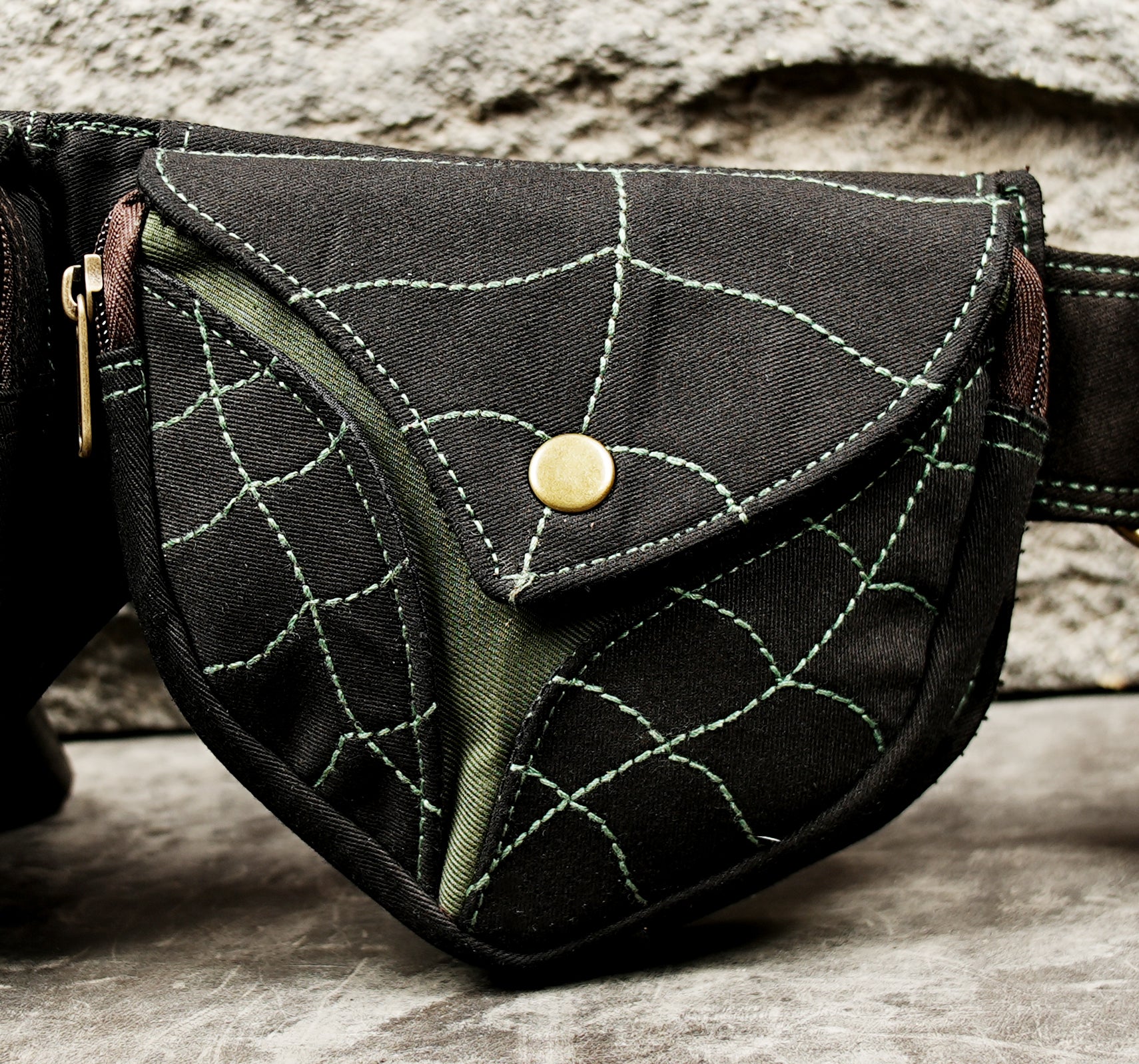 Black canvas hip pouch belt with brown leaf inserts and green contrast stitching