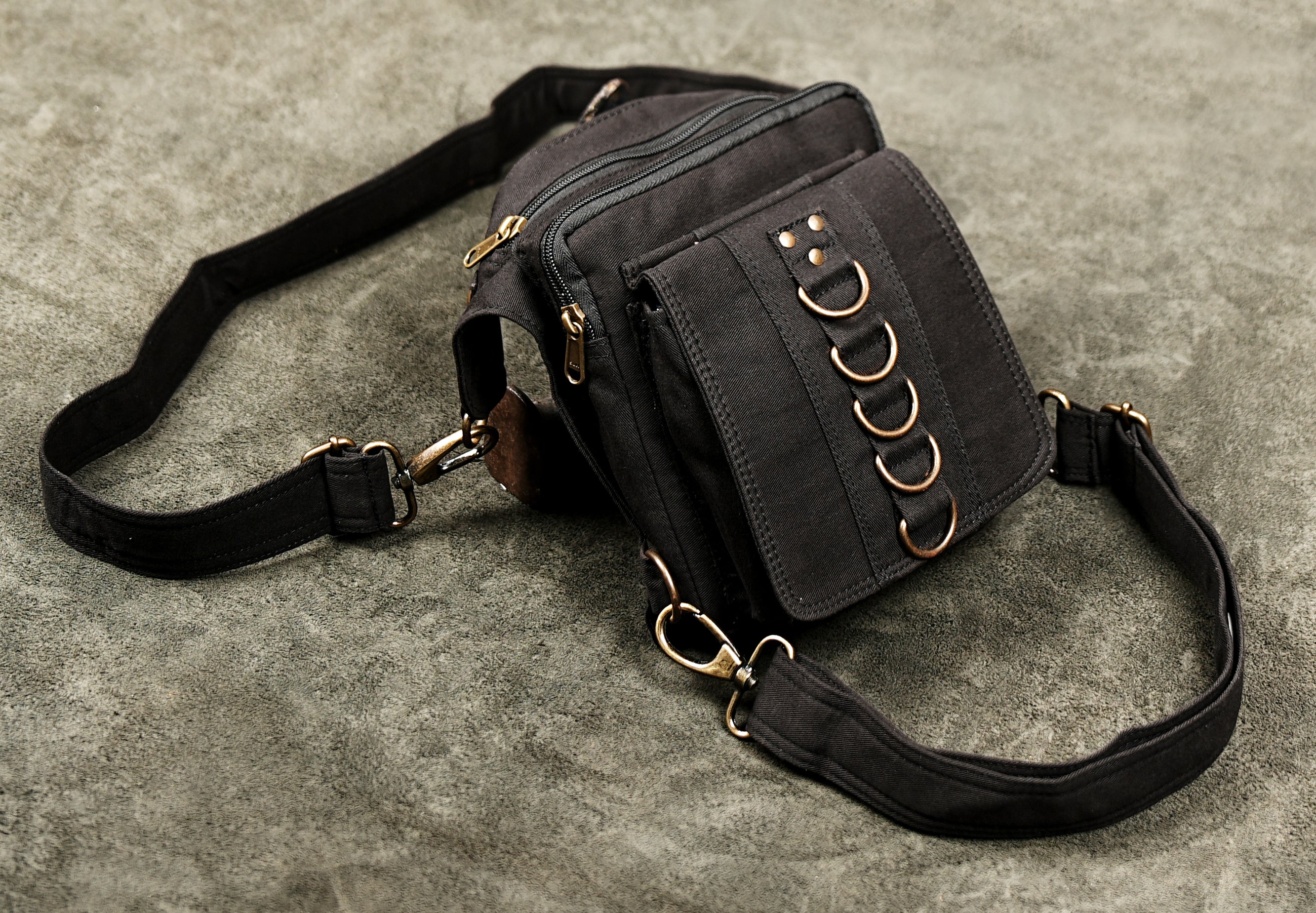 Black cotton utility pouch with multiple metal rings and a hands-free design