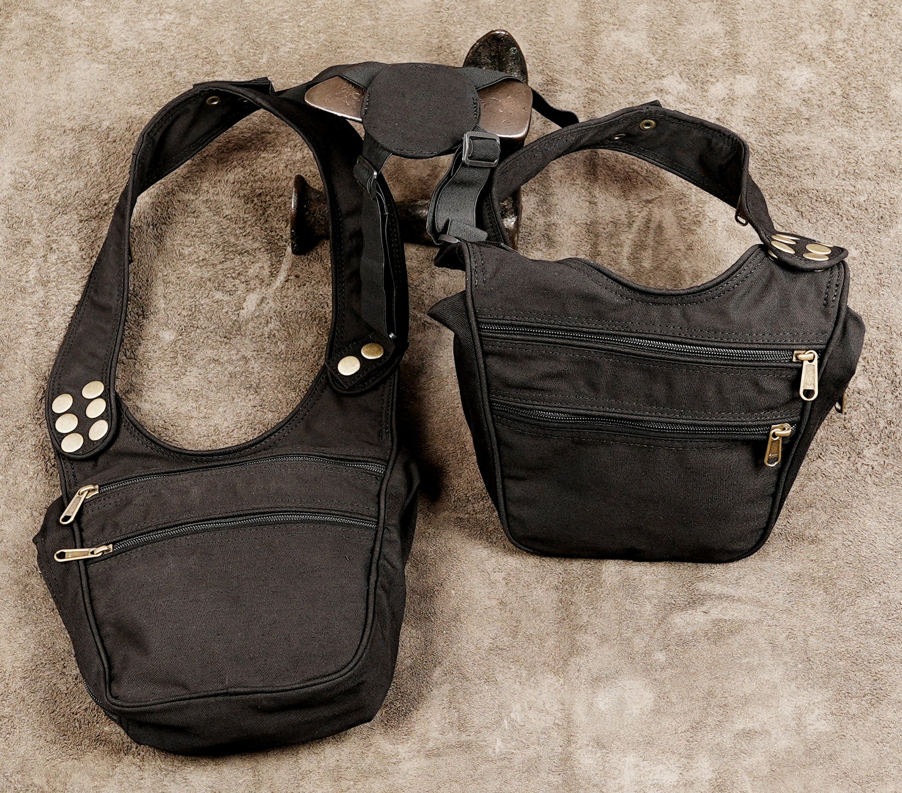 A black canvas crossbody bag with multiple zippered pockets and adjustable straps