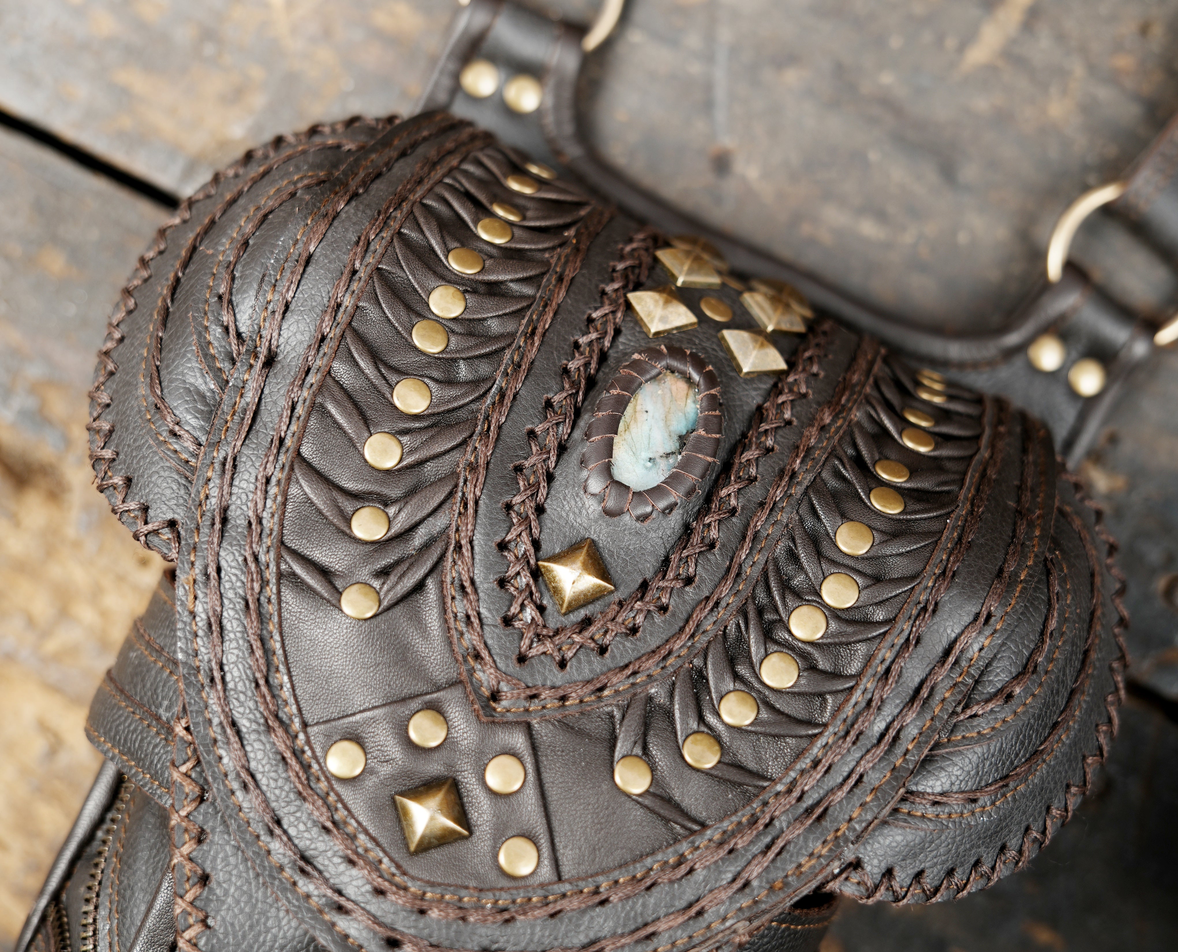 “Tribal-inspired brown leather holster featuring decorative stitching and studs”