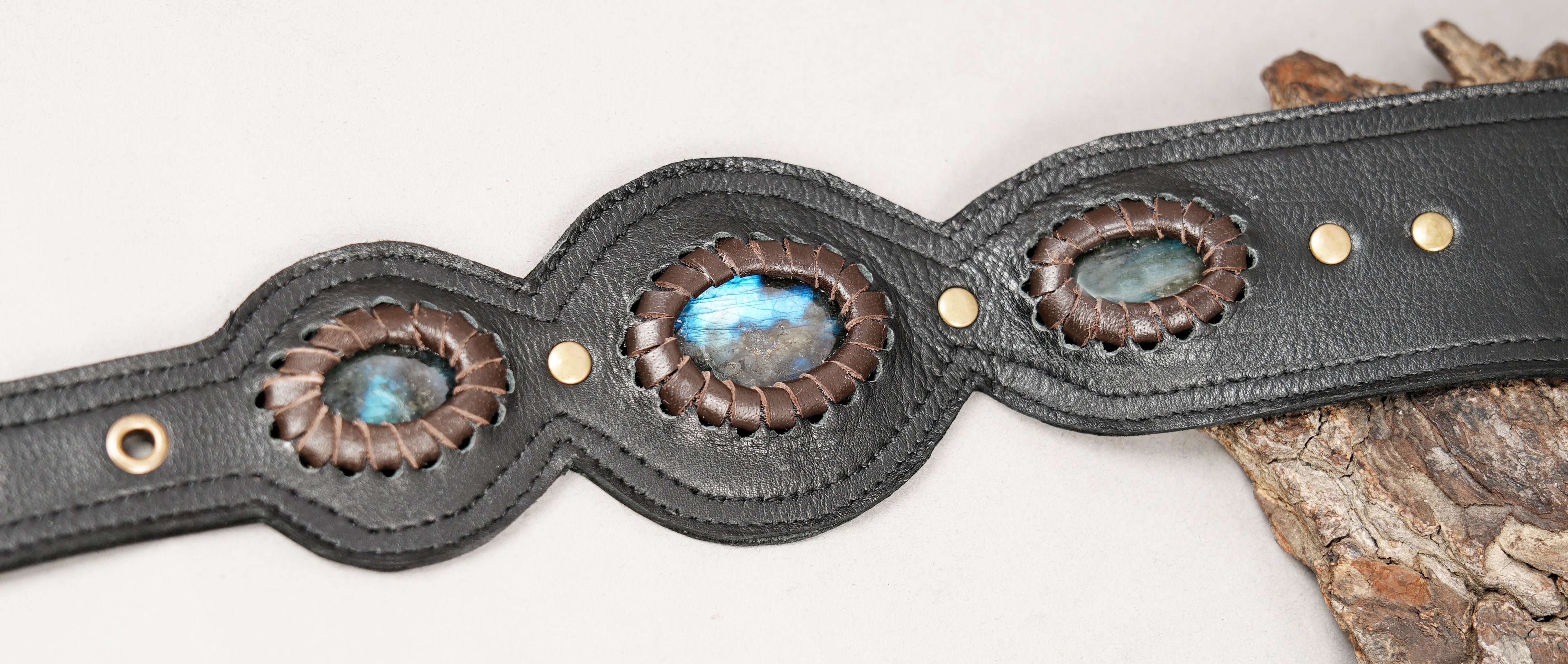 Artisan leather holster featuring silver embossed patterns and blue stones