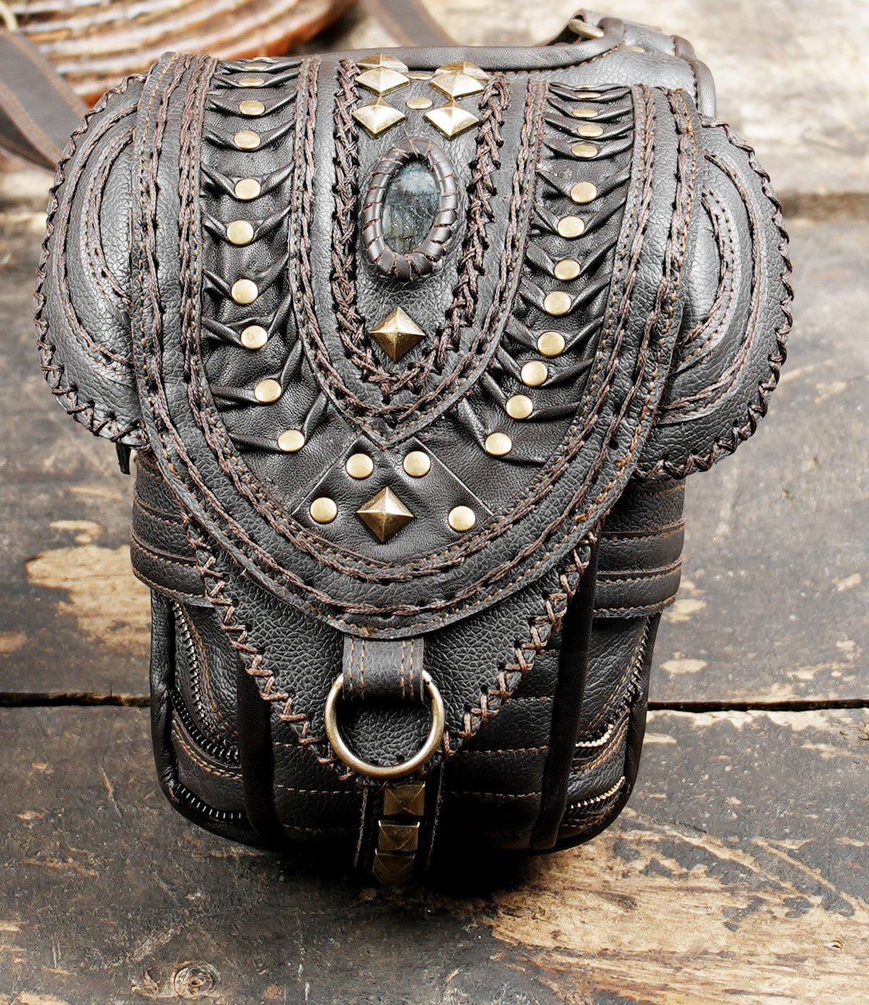 “Artisan leather shoulder holster with dual pouches and gemstone centerpiece”