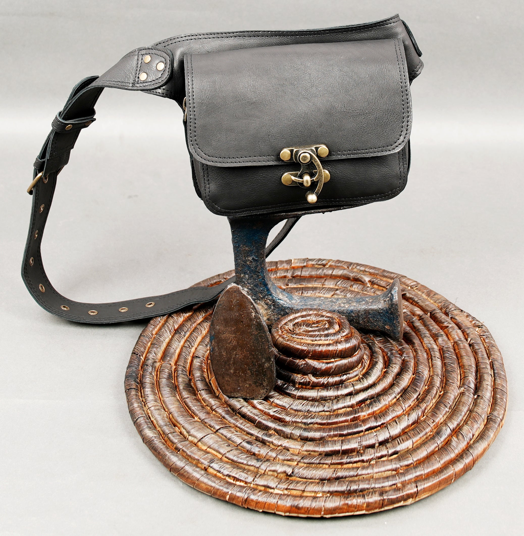 Black leather waist pack with durable stitching and brass details
