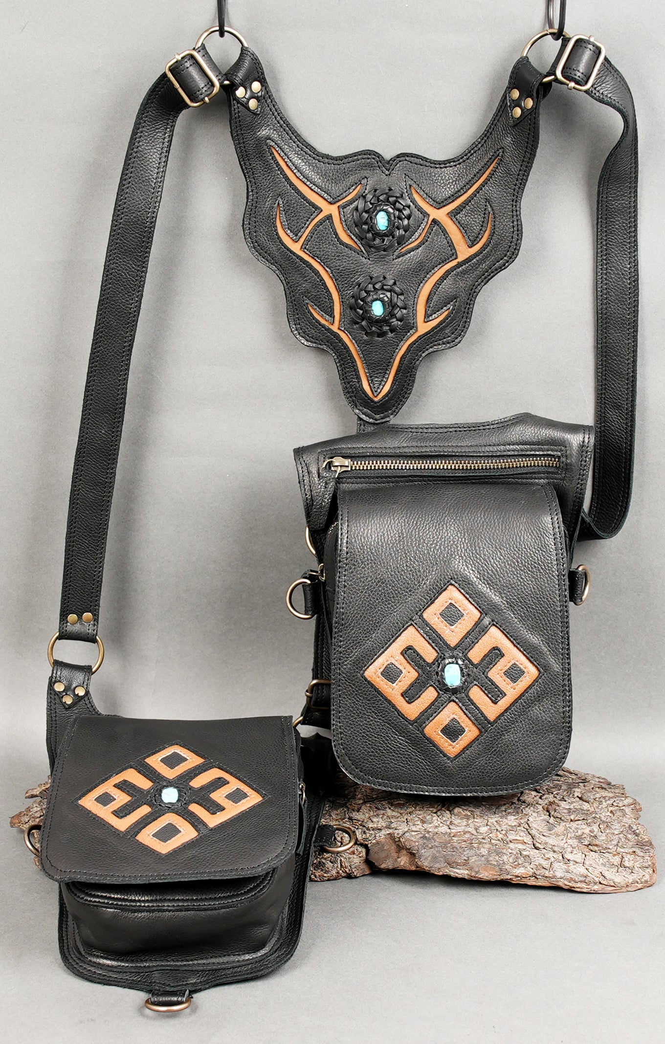 Tribal-patterned black leather bag with metal buckle details.
