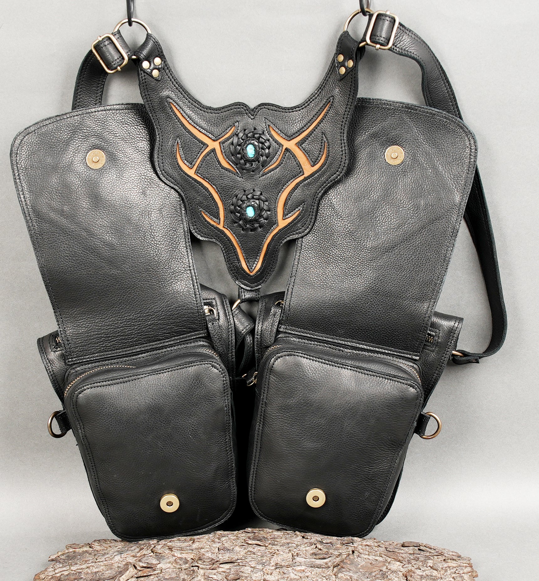 Black leather crossbody harness with unique geometric embossing.