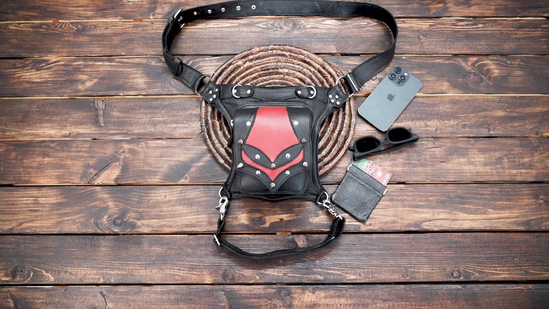 Close-up of handmade gothic leather thigh pouch with red panel design