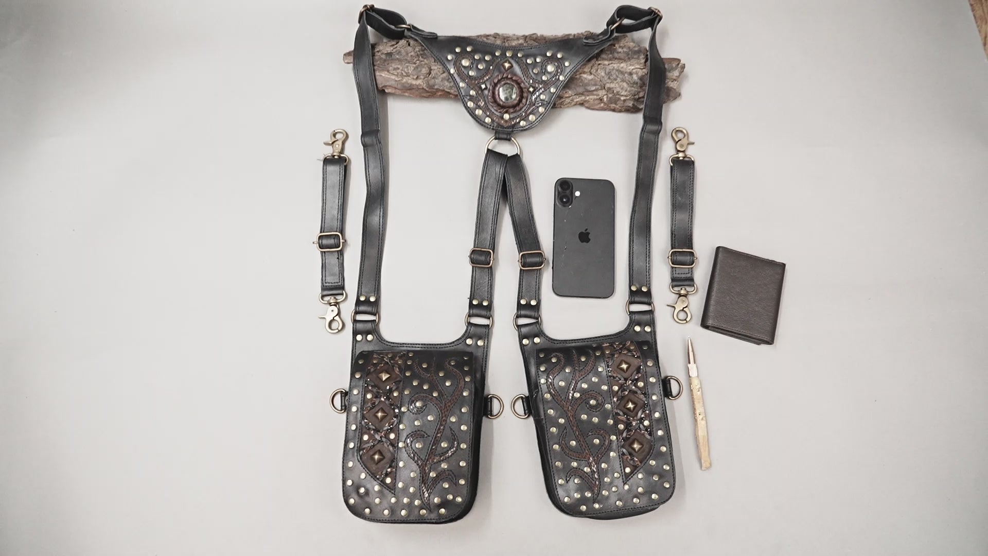 Black leather utility holster with decorative studs and gemstone buckle detail