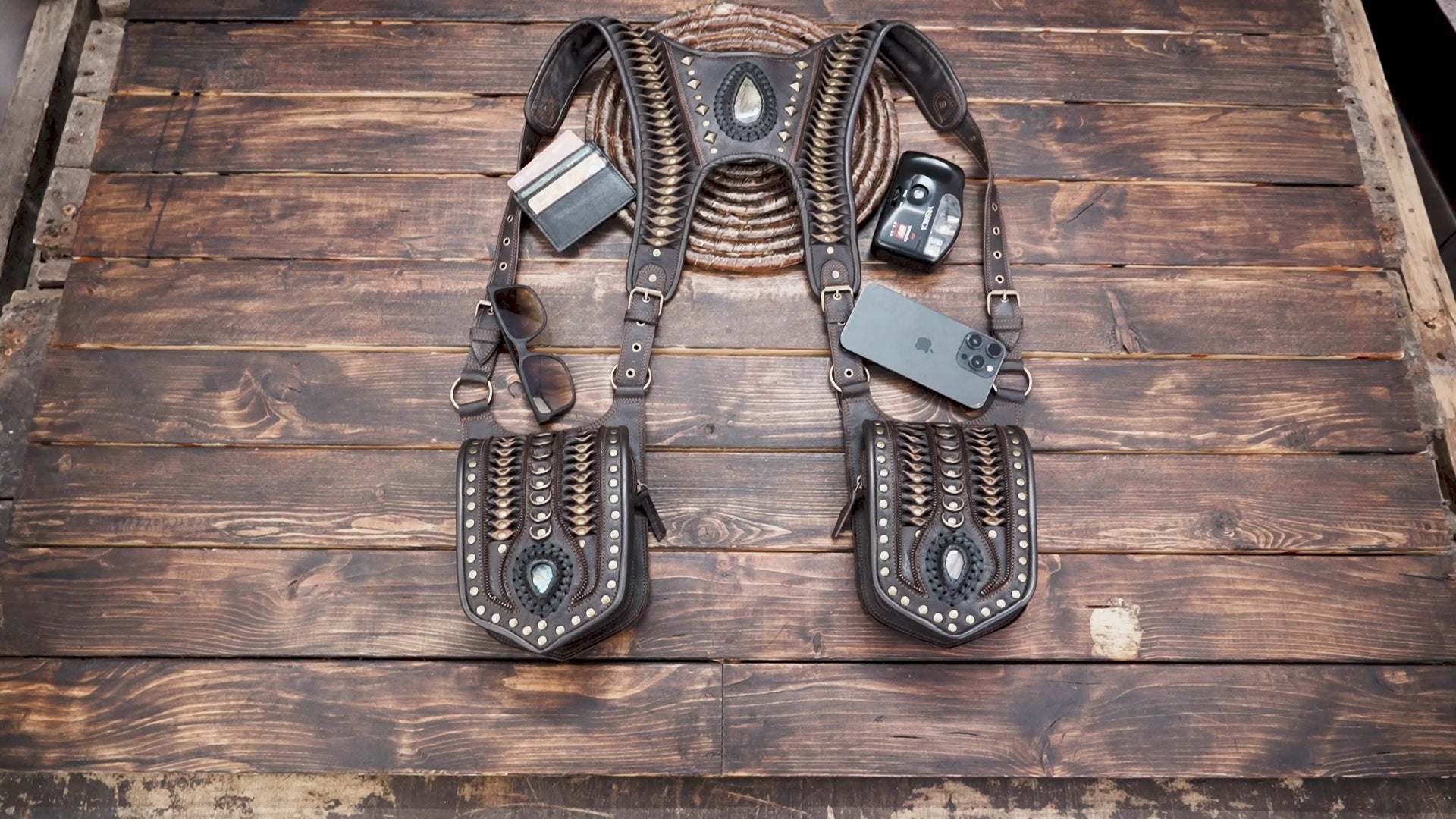 Close-up of brown leather holster bag with blue gemstone inlay and brass studs