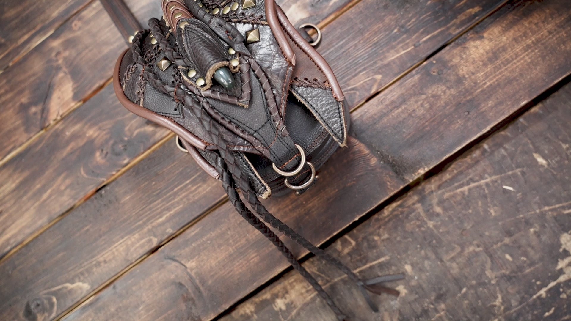 “Handcrafted tribal leather holster with braided details and green gemstone centerpiece”