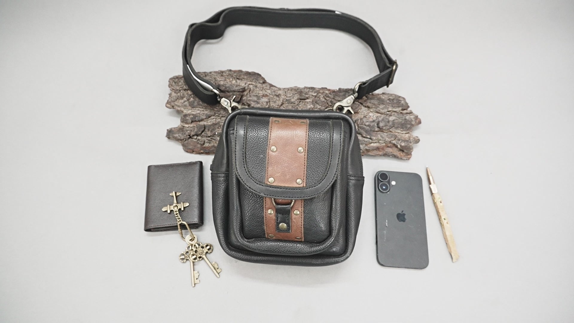 Artisan leather waist belt bag with flap closure and rivet details