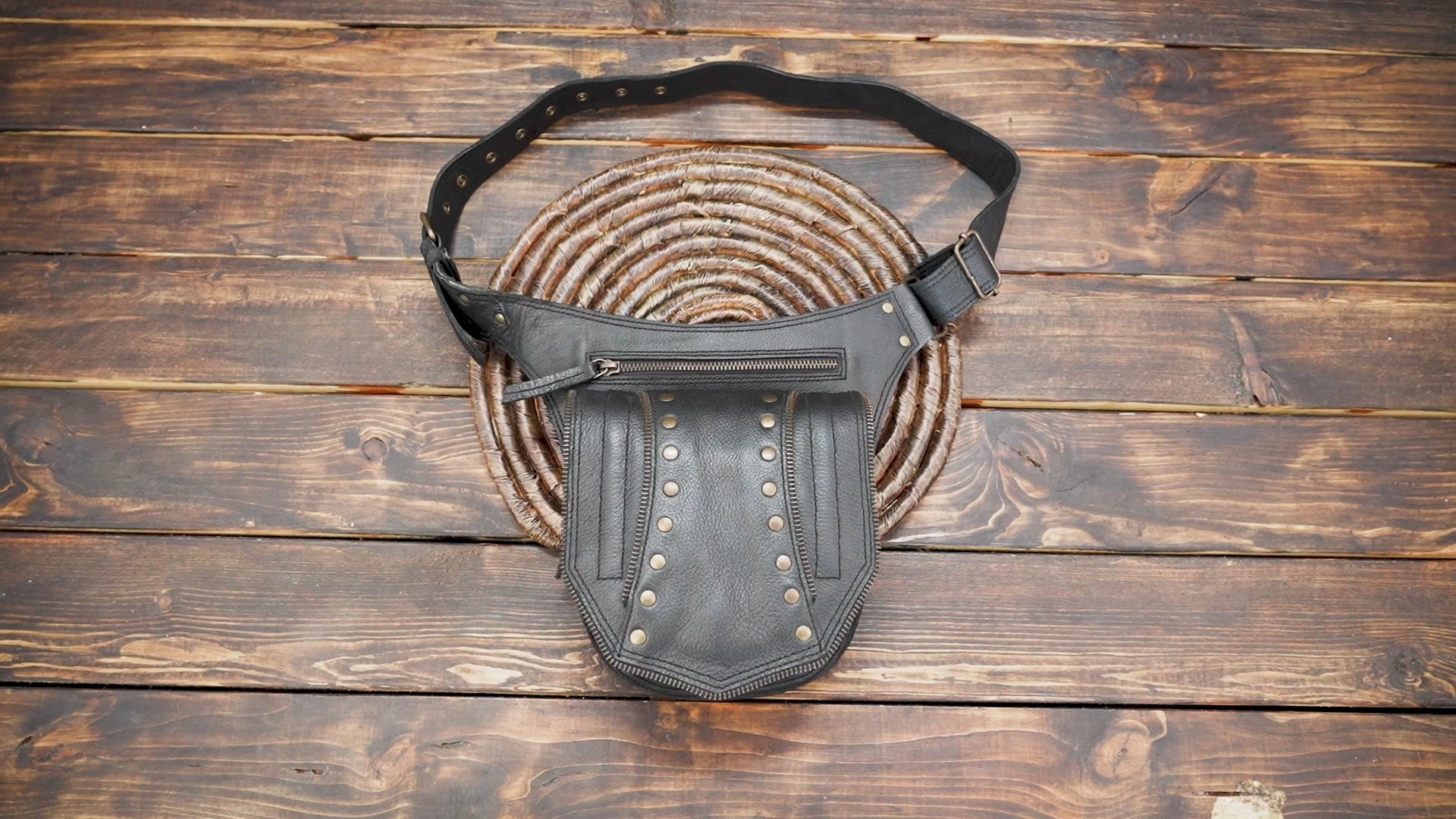 Side angle of black leather waist bag with detailed stitching