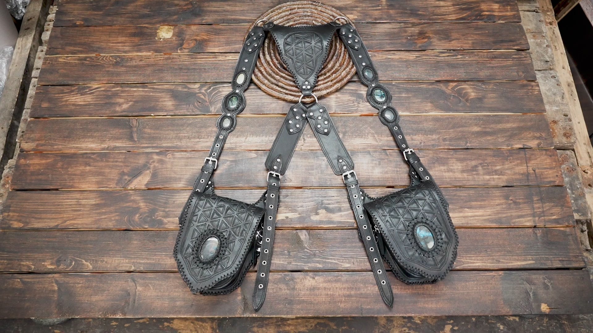 Artisan-made leather shoulder holster with detailed stitching and stone accent