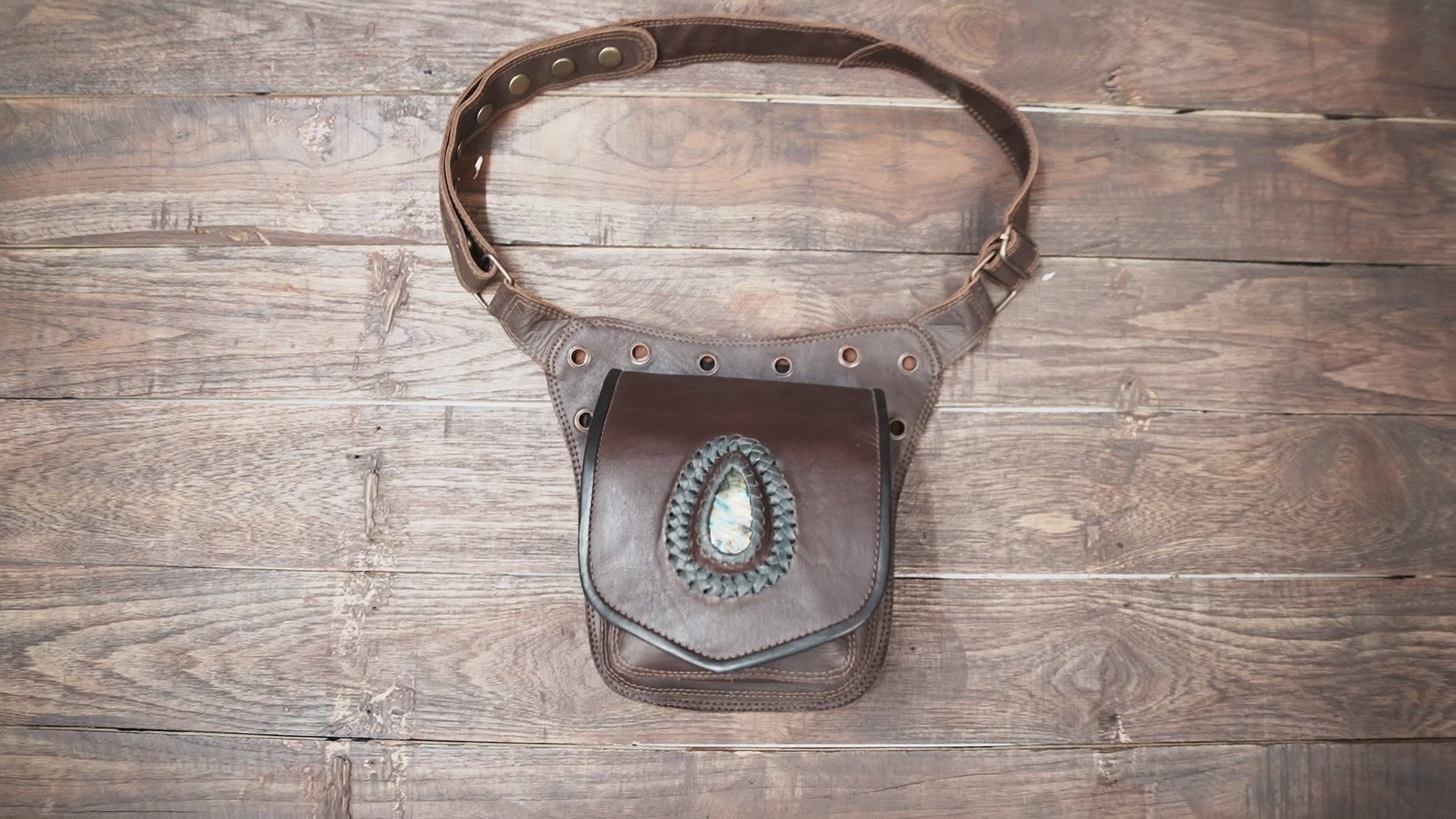 Close-up of gemstone detail on brown leather waist pouch